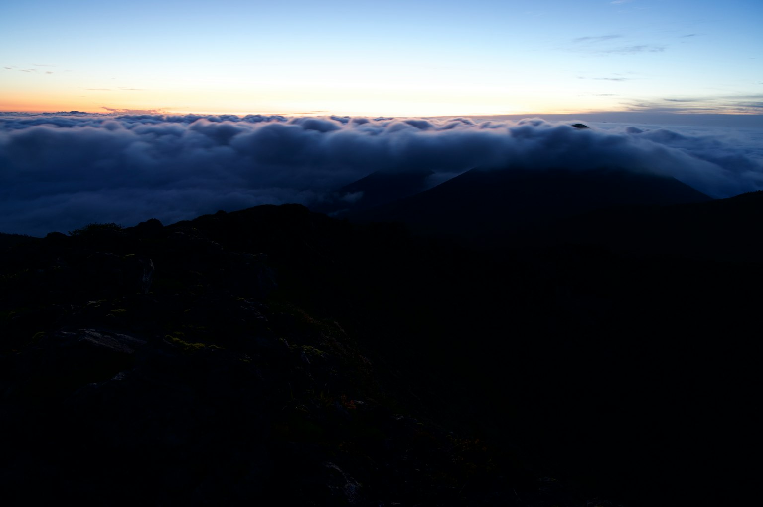 Paesaggio all'alba con un mare di nuvole e montagne
