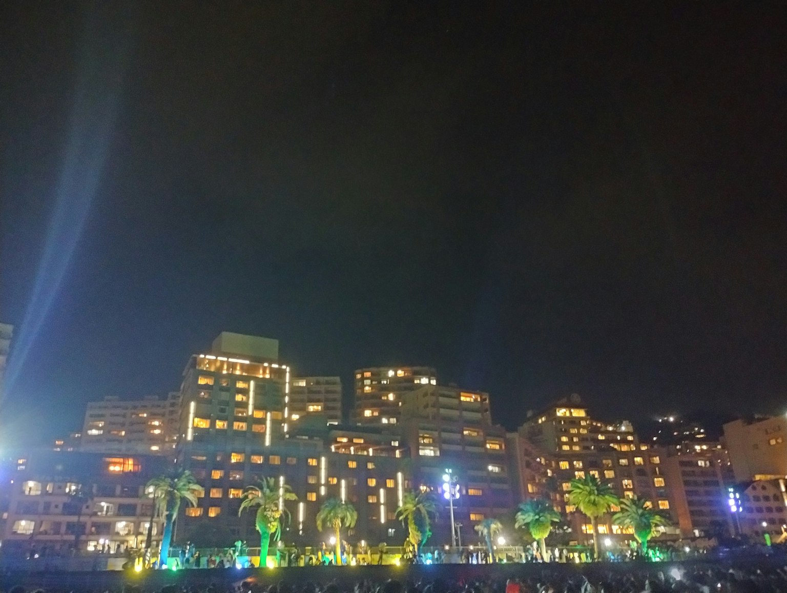 Paysage urbain nocturne avec des gratte-ciels illuminés et des lumières colorées