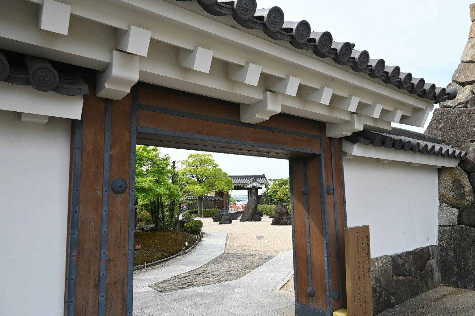Traditional Japanese architecture featuring a wooden gate and white walls