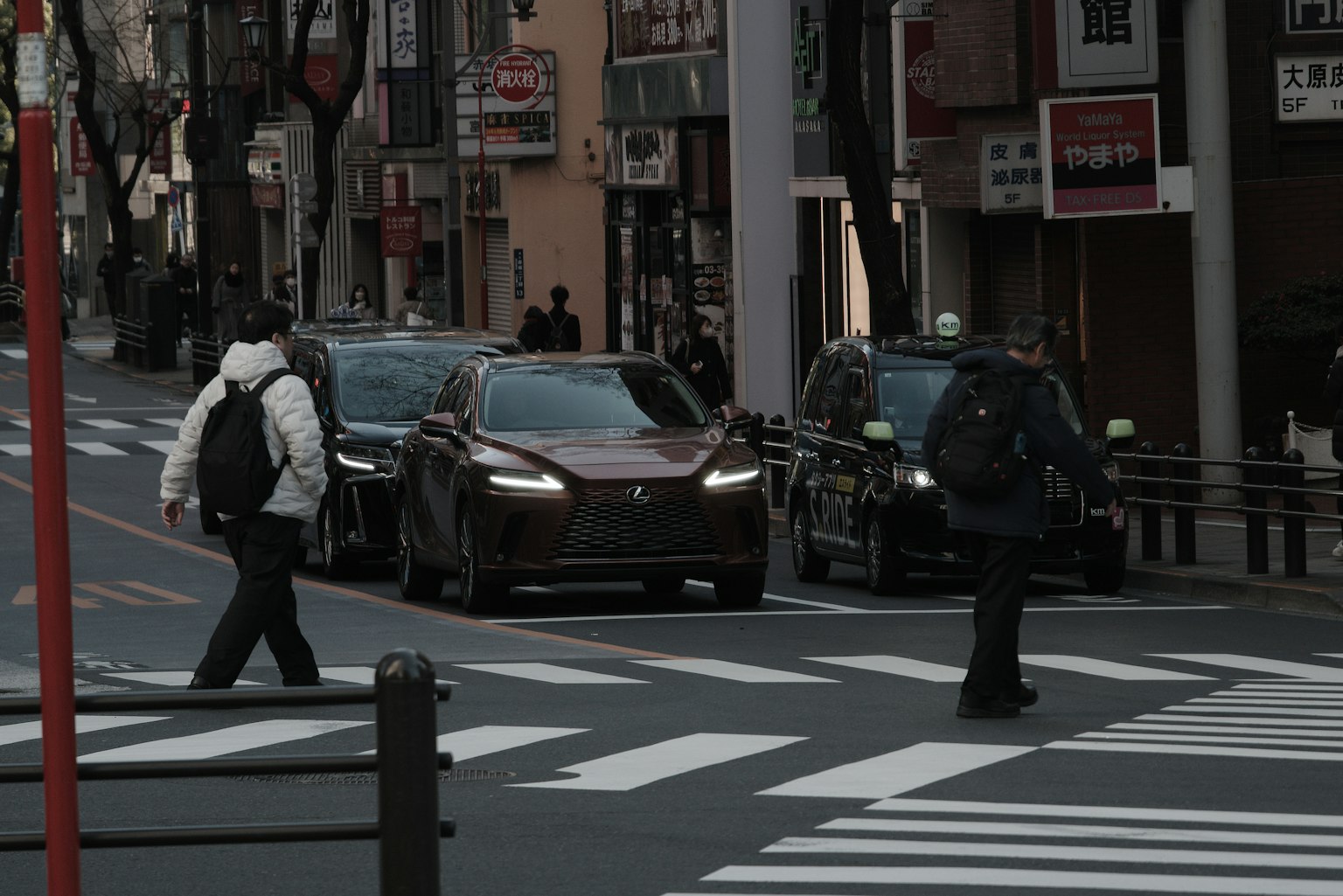 城市景观，人们正在过马路，汽车经过