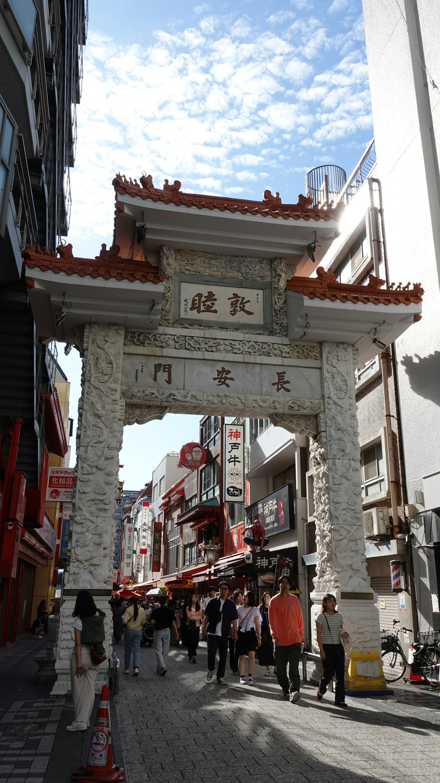 Tor des Chinatowns mit belebter Straße und Geschäften