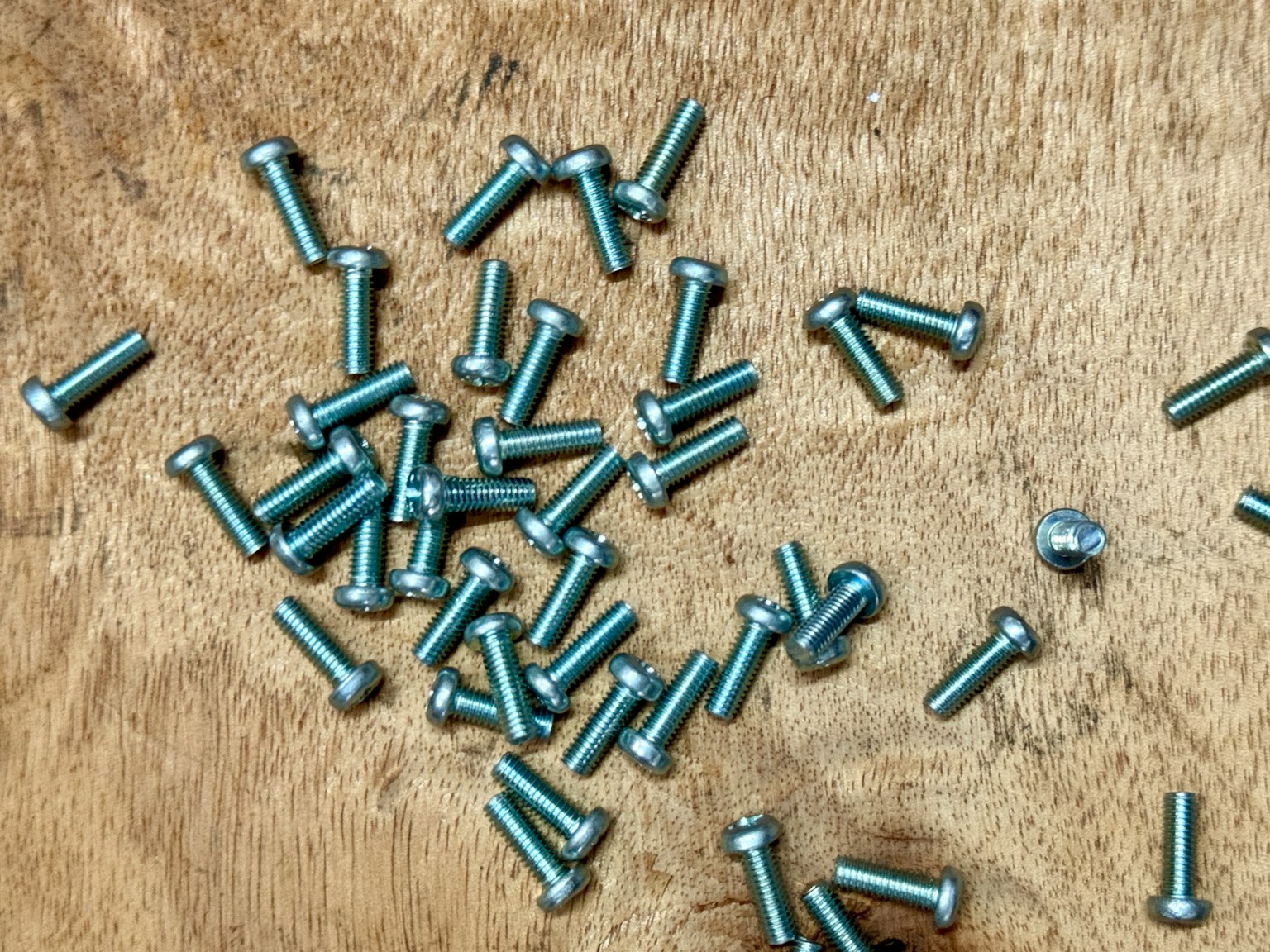 Vis métalliques éparpillées sur une surface en bois