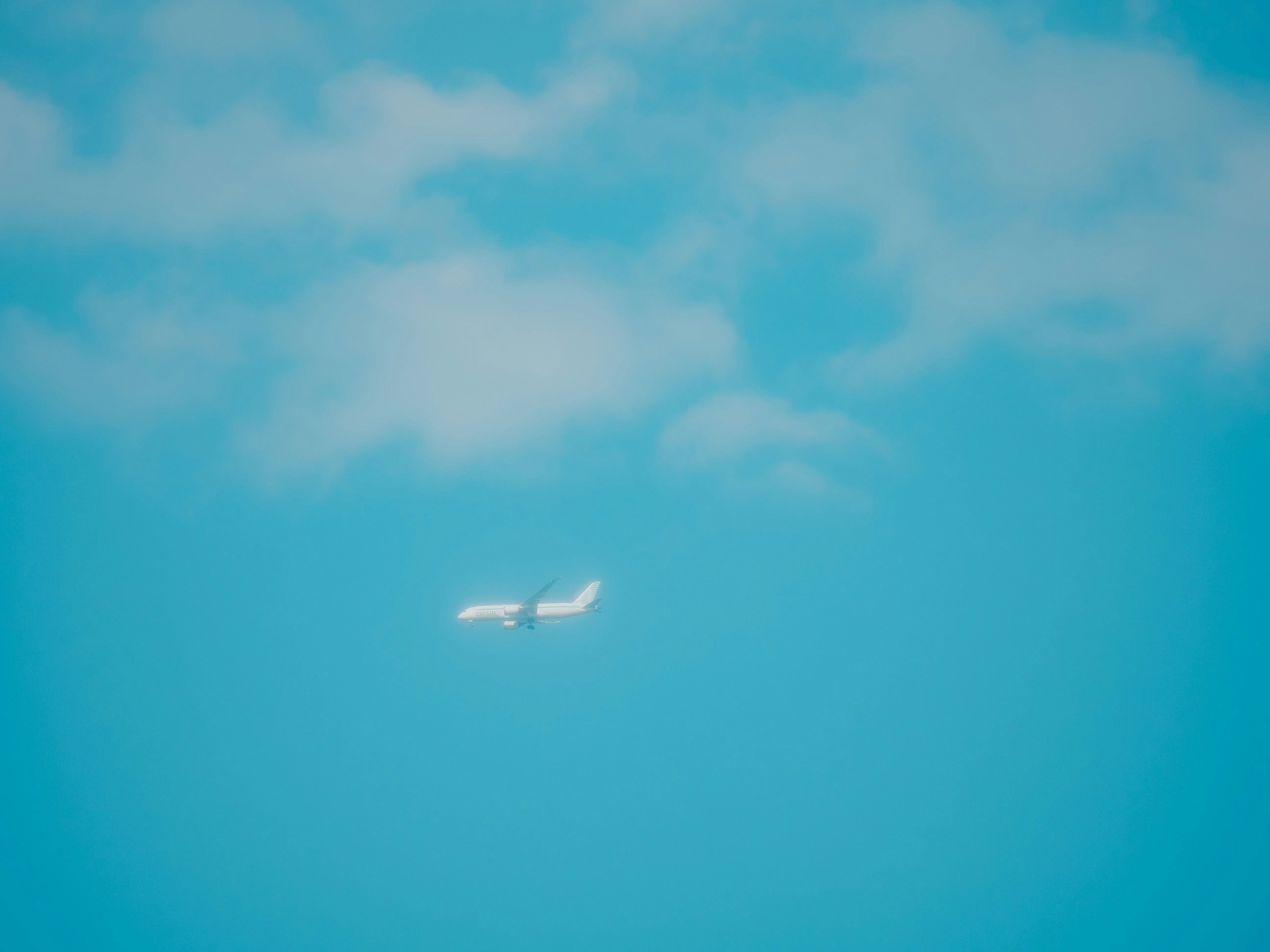 青空の下を飛ぶ小さな飛行機