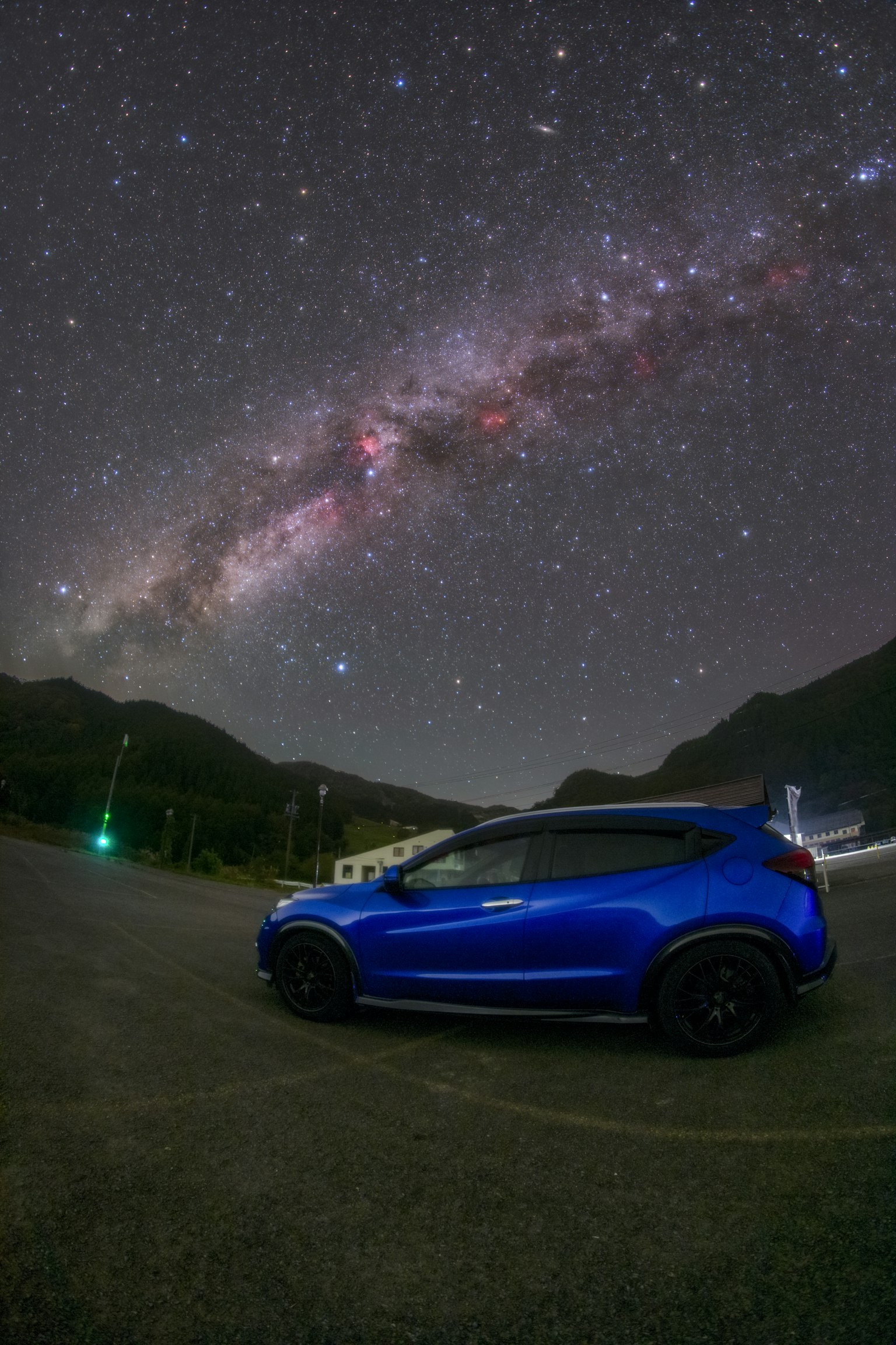 Une voiture bleue sous un magnifique ciel étoilé