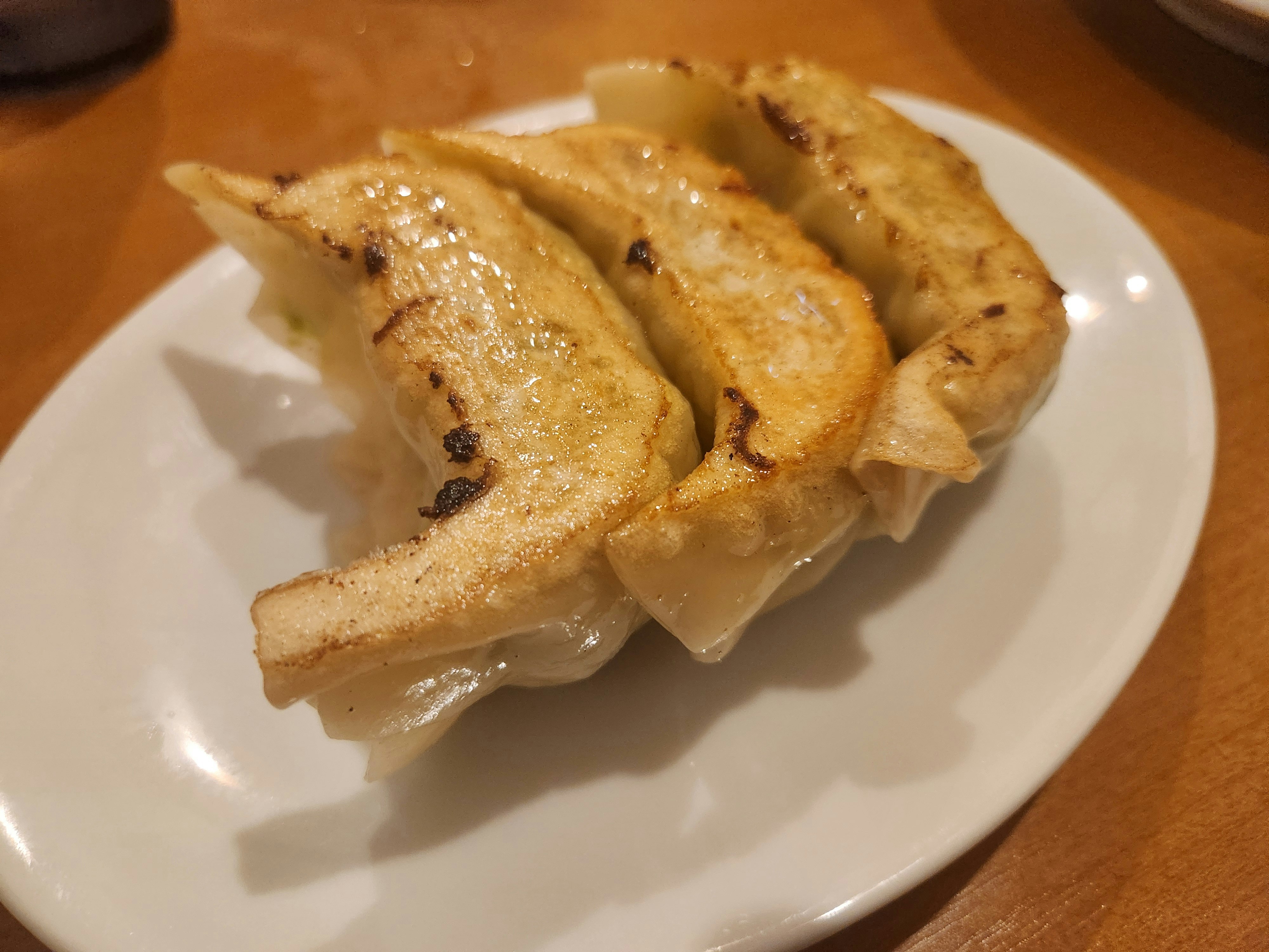 焼き餃子が並ぶ白い皿