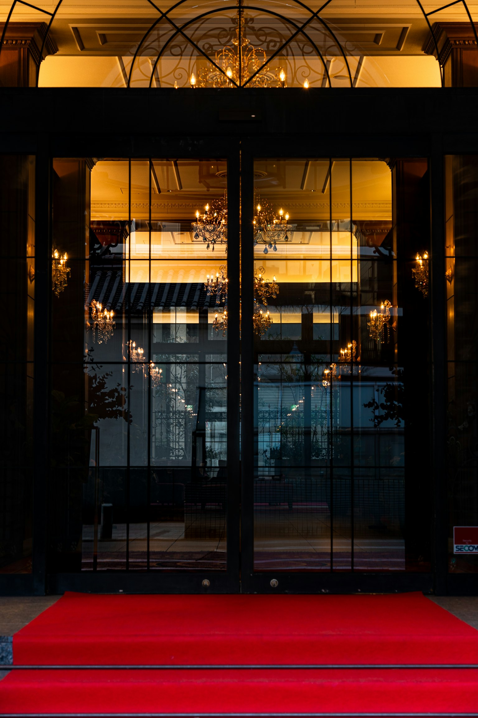 Entrada elegante con puertas de vidrio y alfombra roja