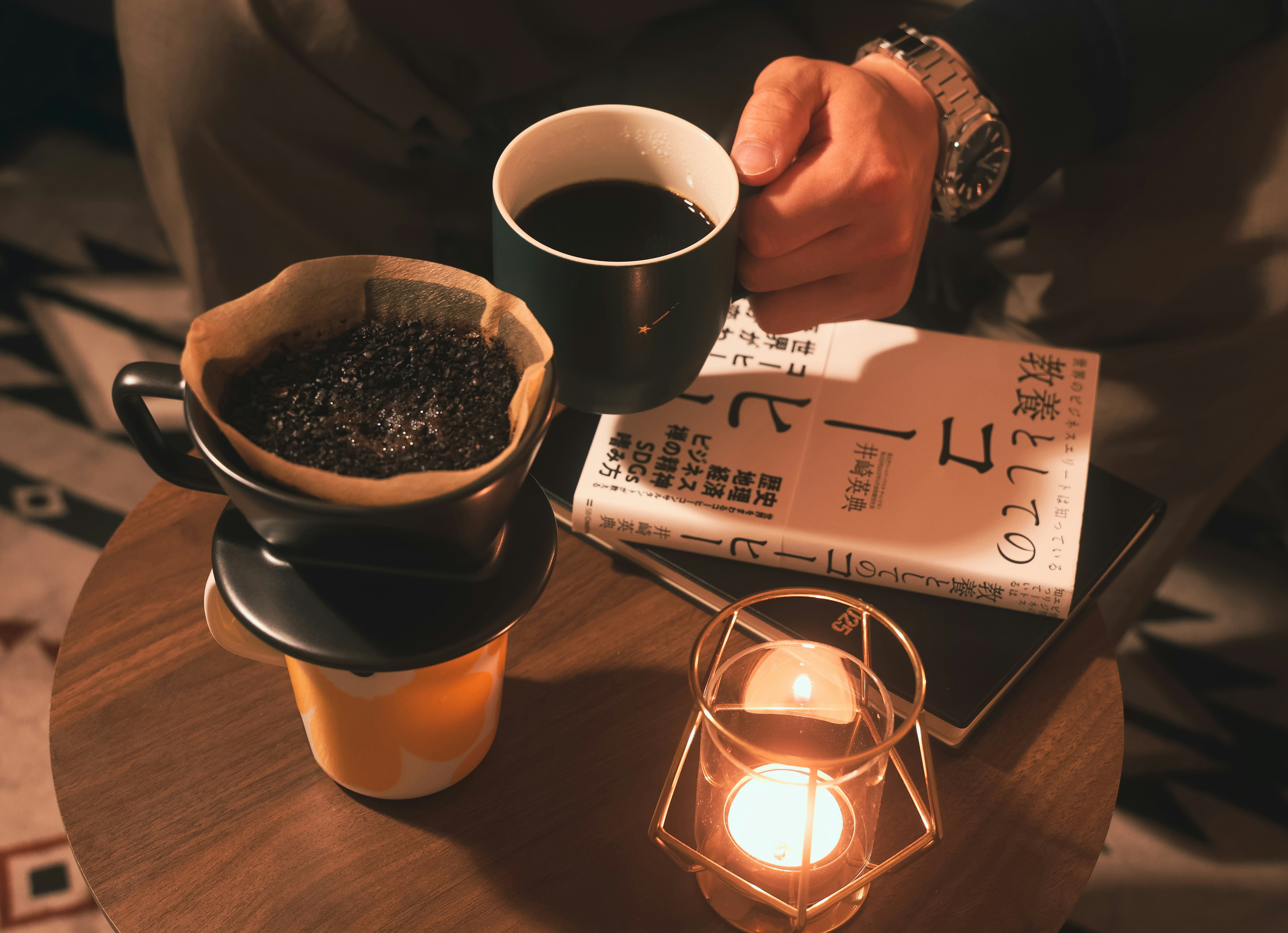 テーブル上のコーヒーと湯気のあるカップ、灯りのランタン