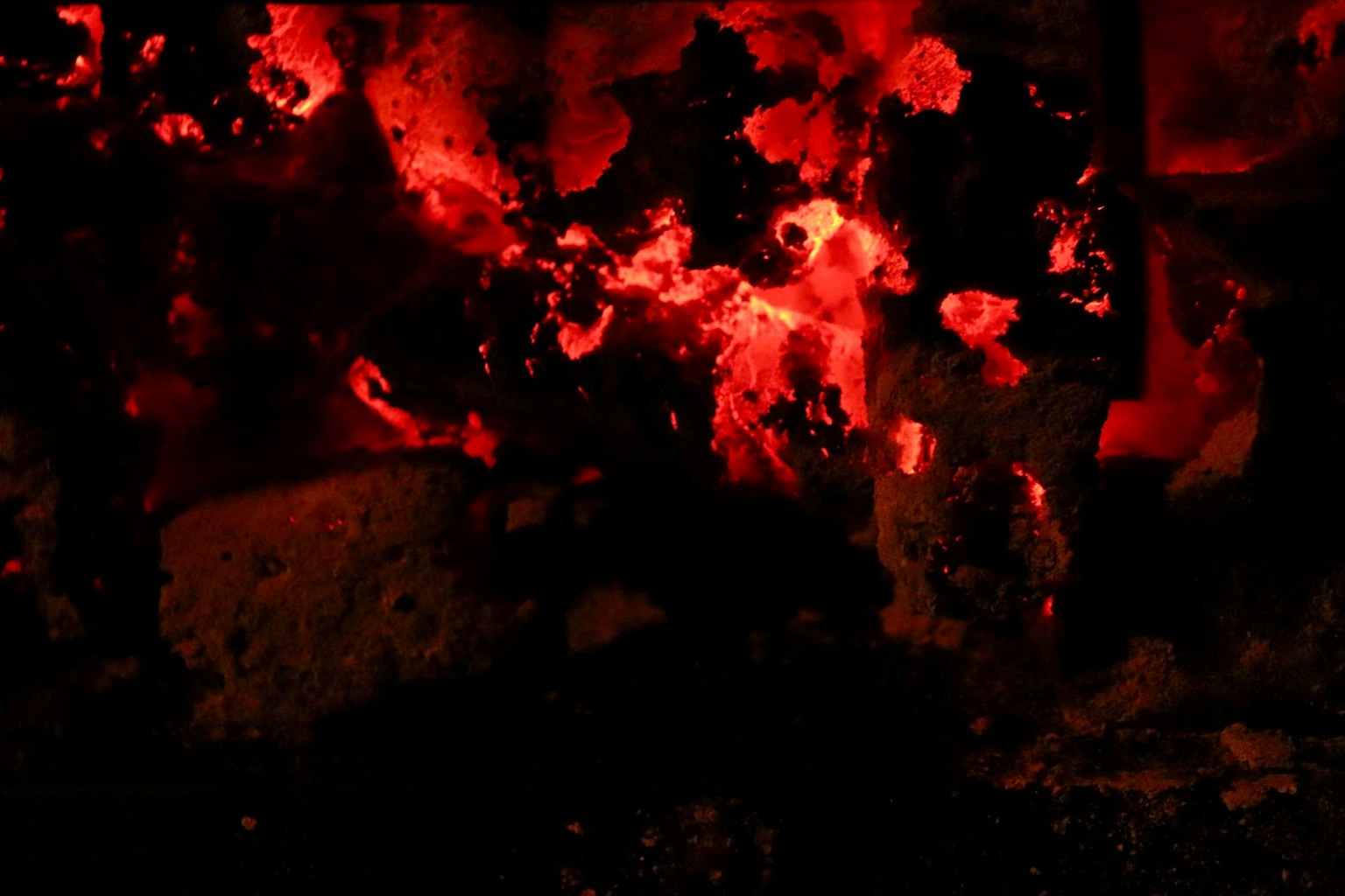Una escena de llamas rojas brillantes y cenizas negras