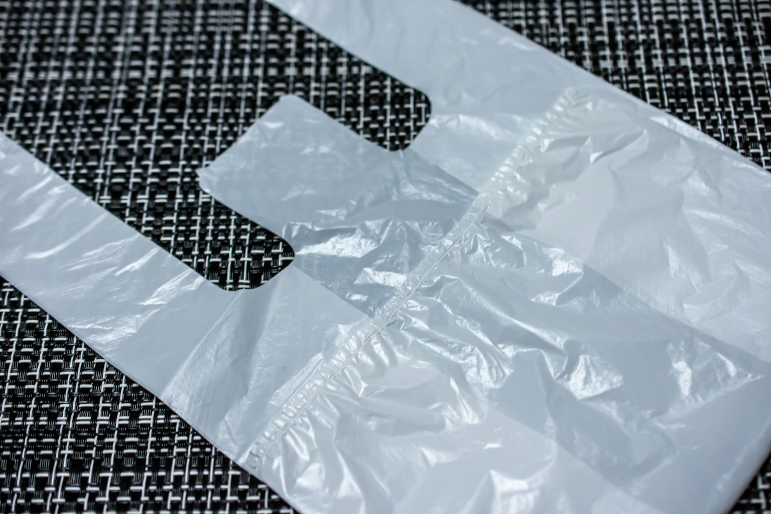 Transparent plastic shopping bag placed on a textured surface
