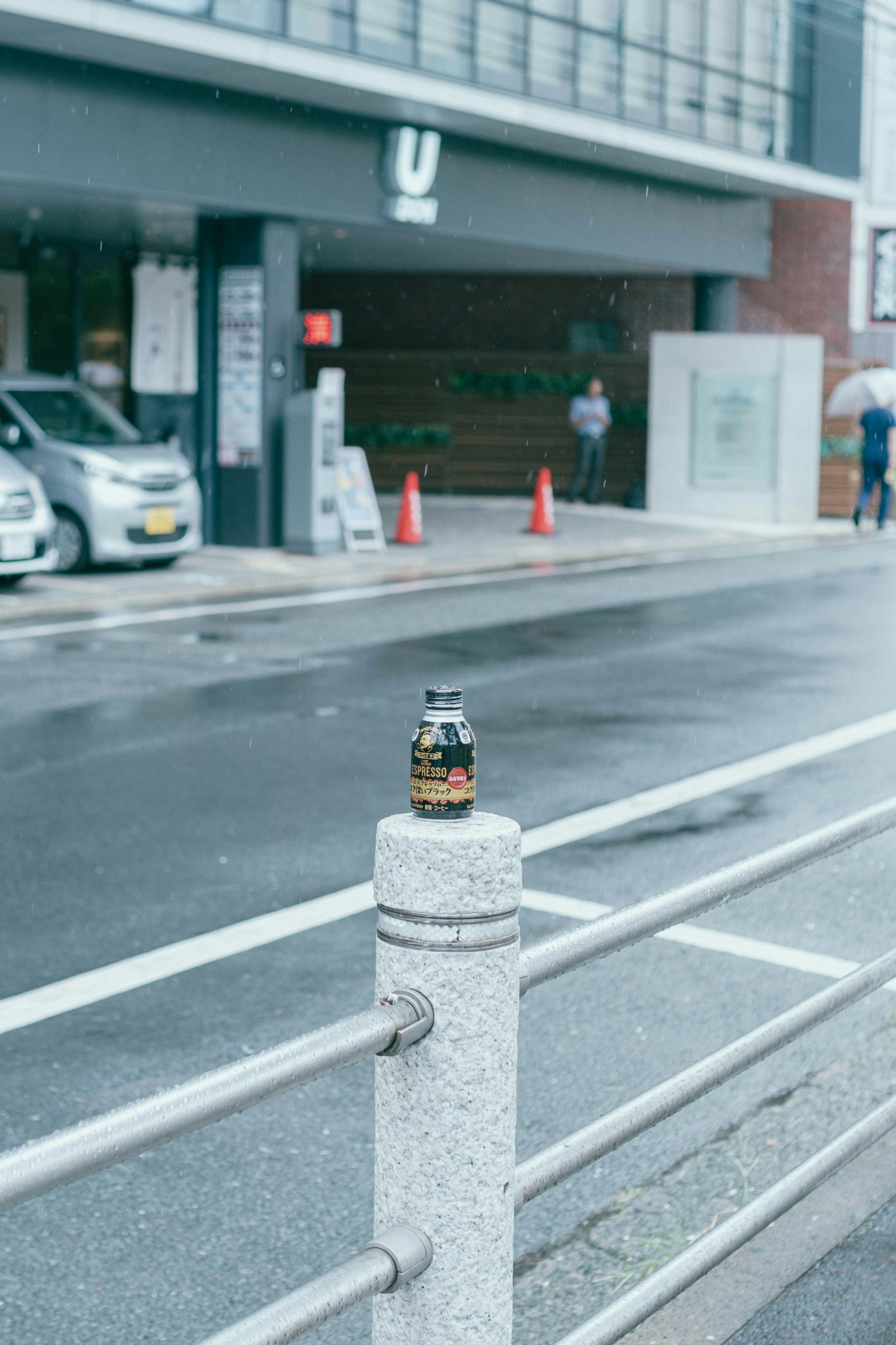 도시 풍경이 배경인 콘크리트 기둥 위에 놓인 음료수 캔