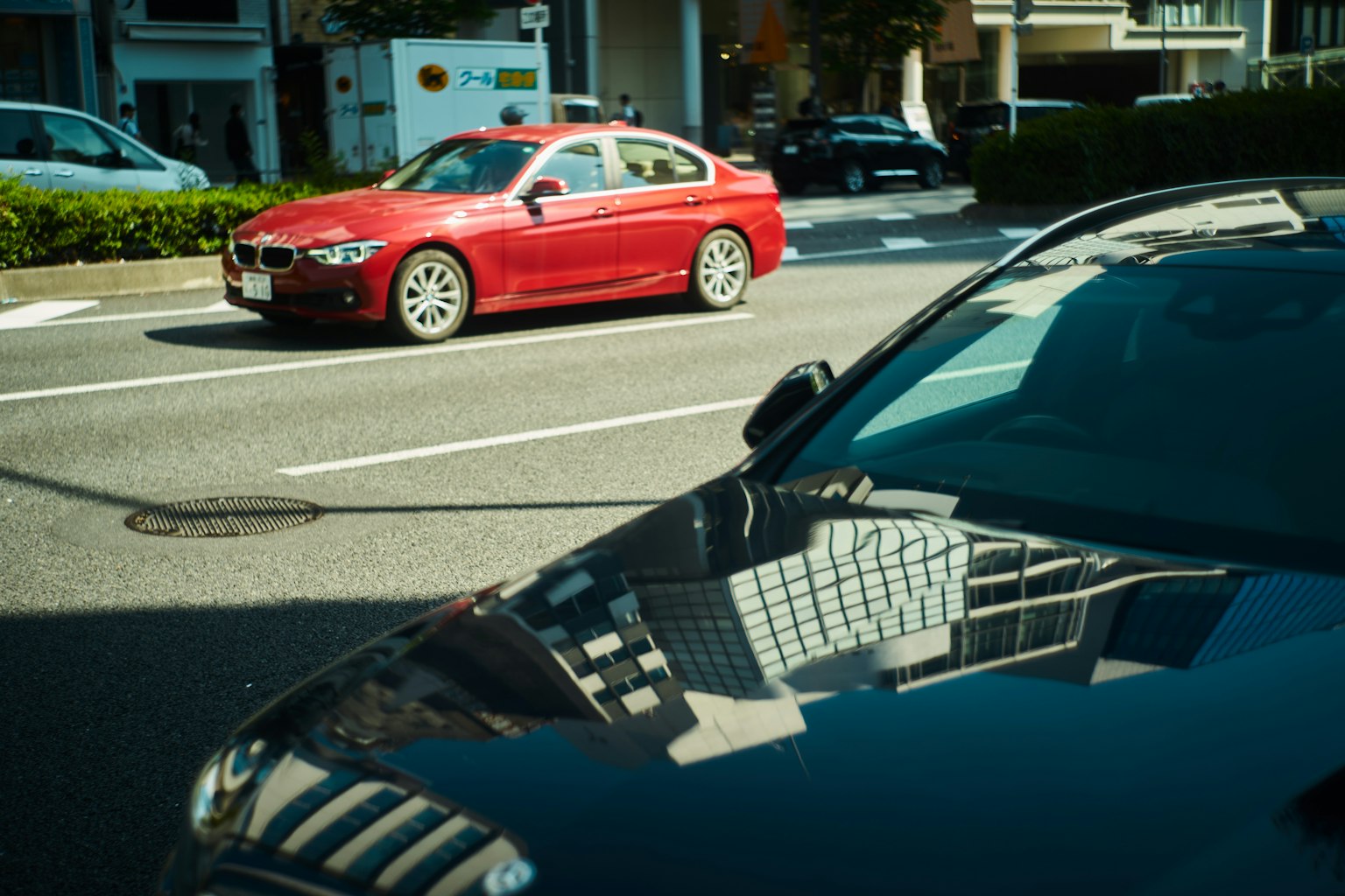 Rotes Auto und schwarzes Auto auf einer Stadtstraße
