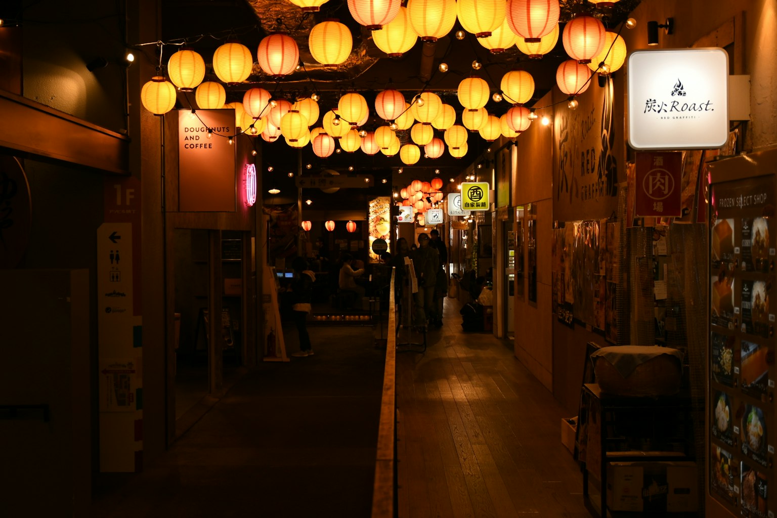 Una vivace strada con lanterne gialle appese in un mercato notturno