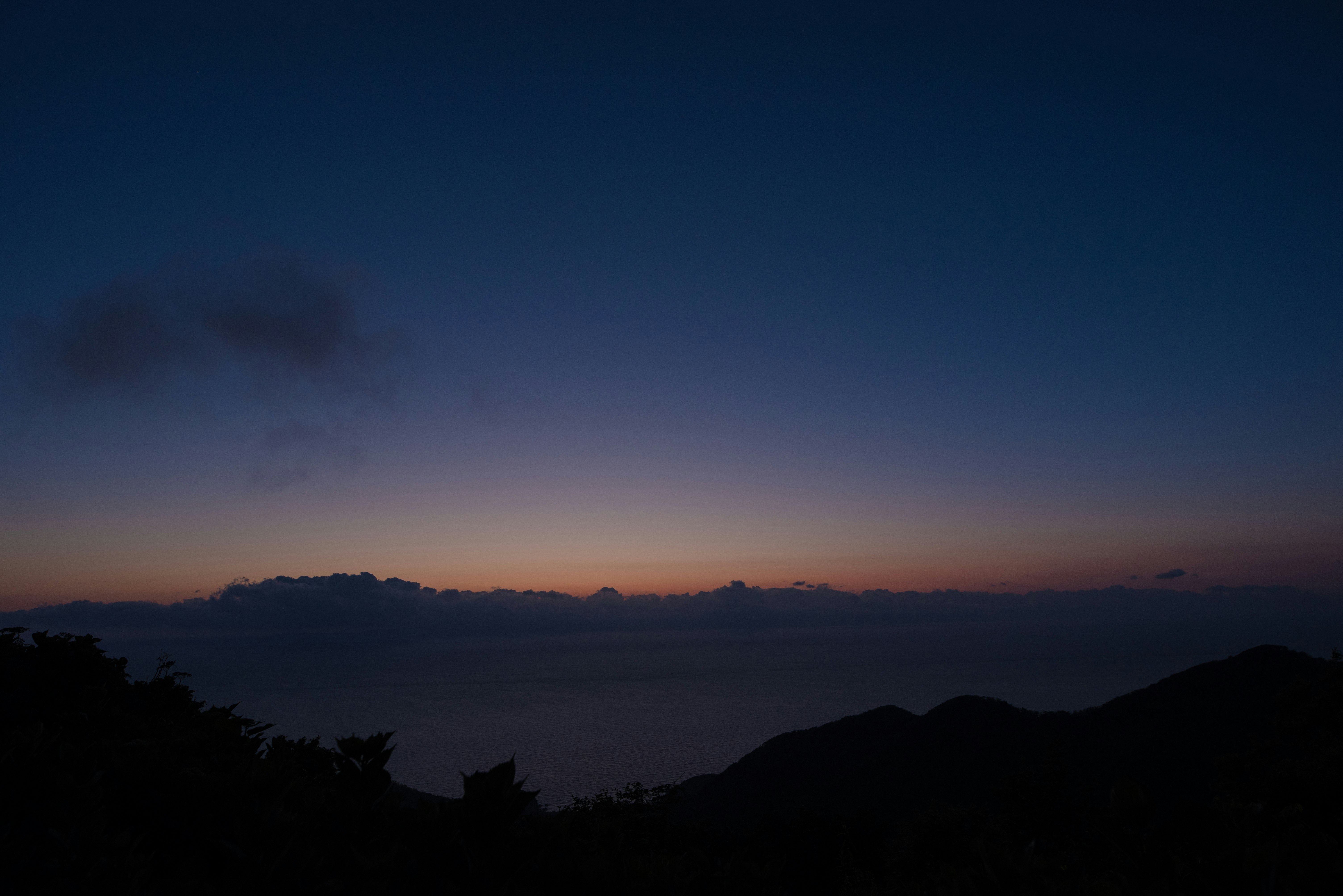 山並みのシルエットと夕暮れの空