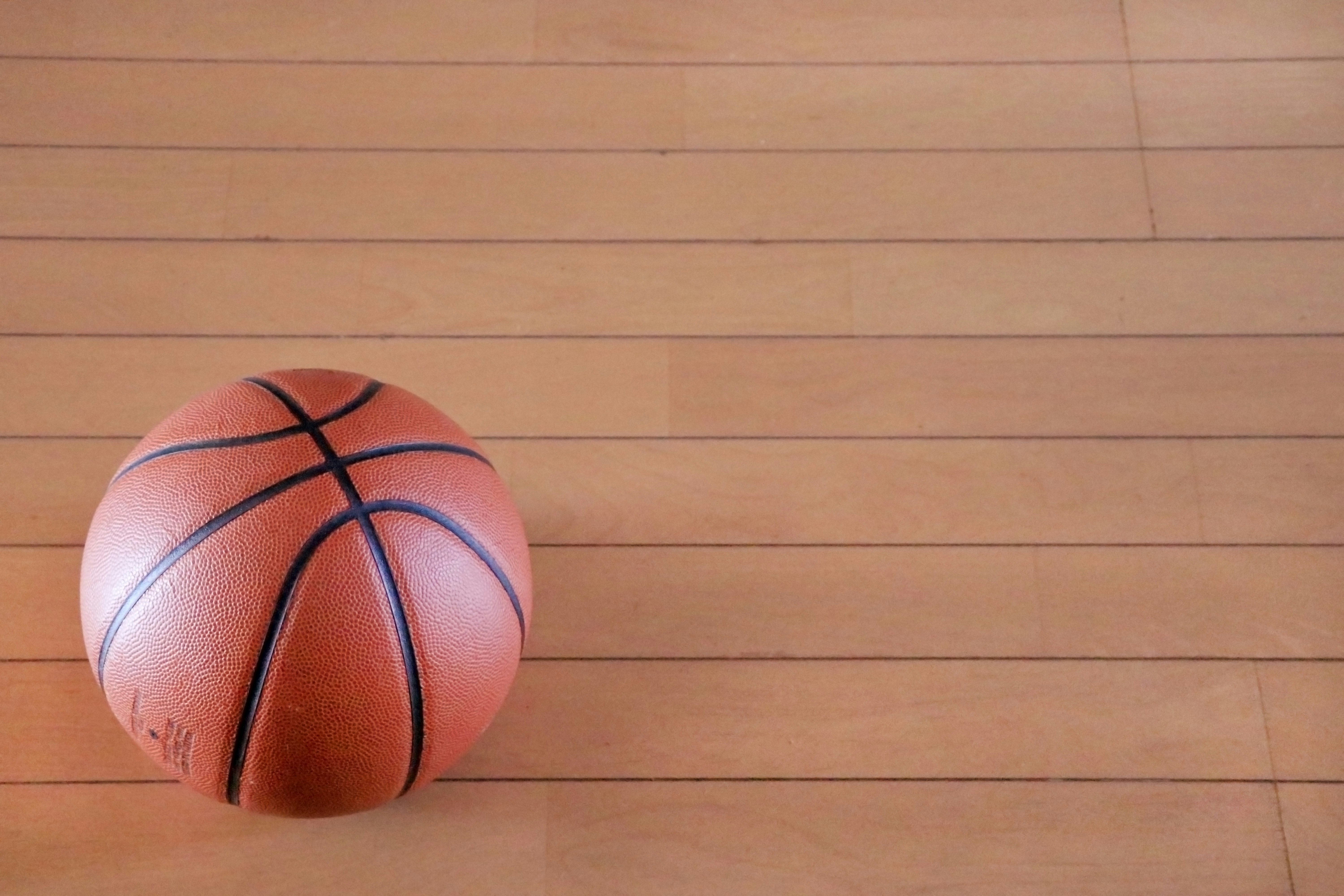 Basketball rolling on a wooden floor