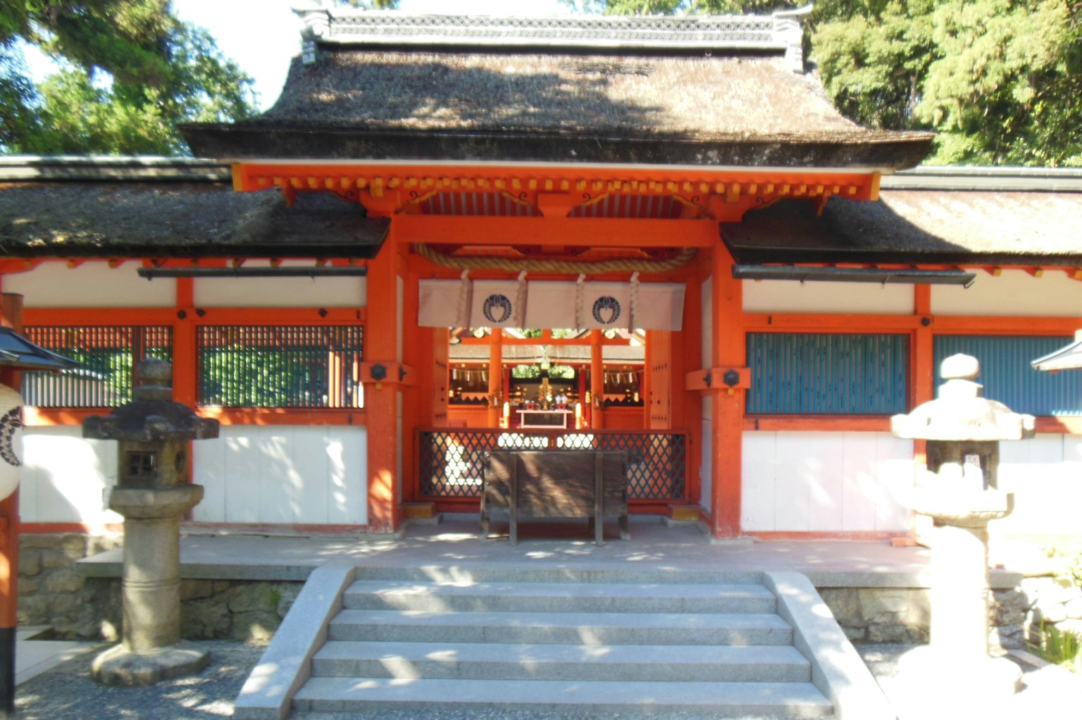 Entrance of a shrine featuring a red gate and stone steps