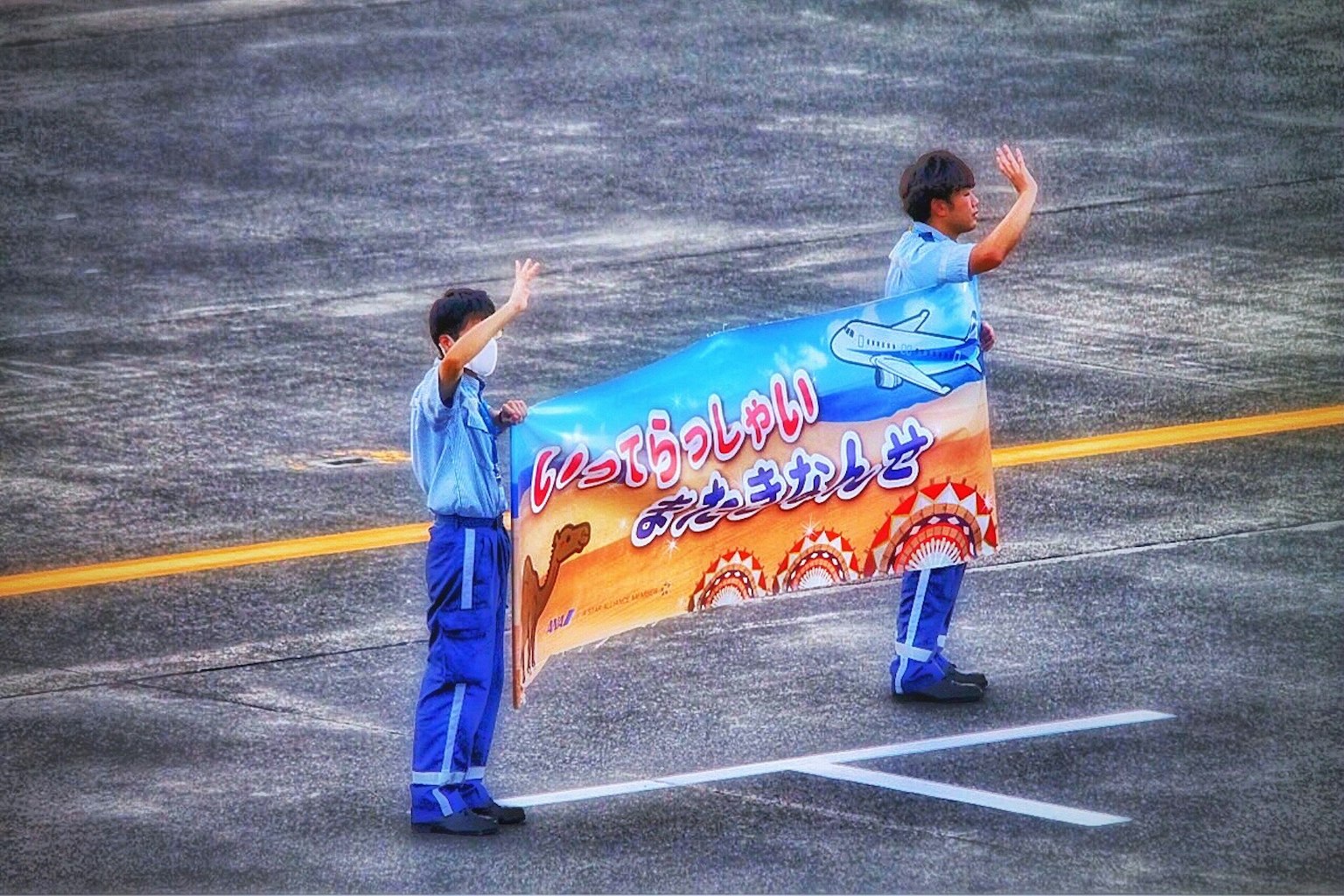 Zwei Personen in blauen Uniformen halten ein großes Banner