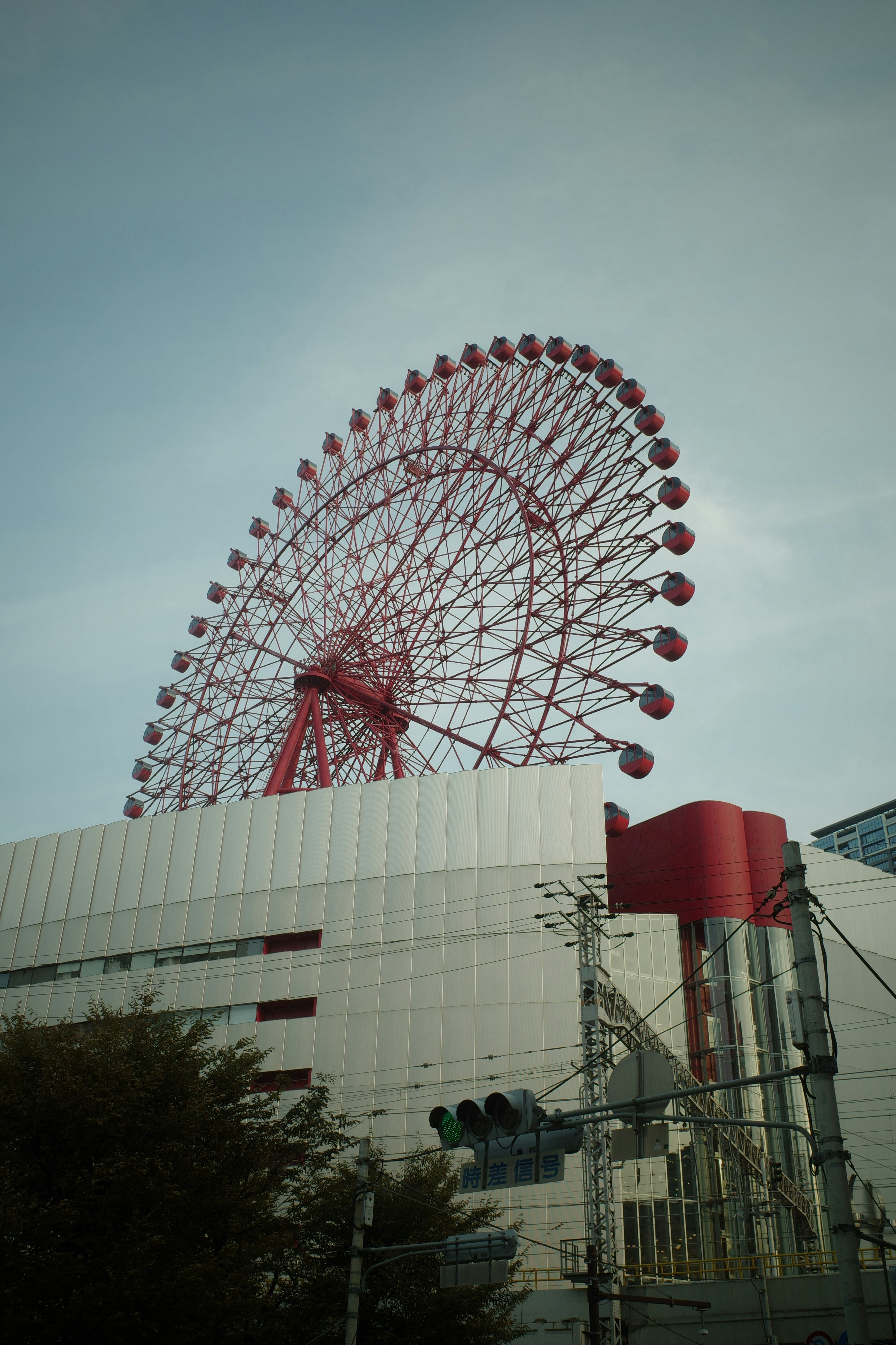赤い観覧車が建物の上にそびえ立つ風景
