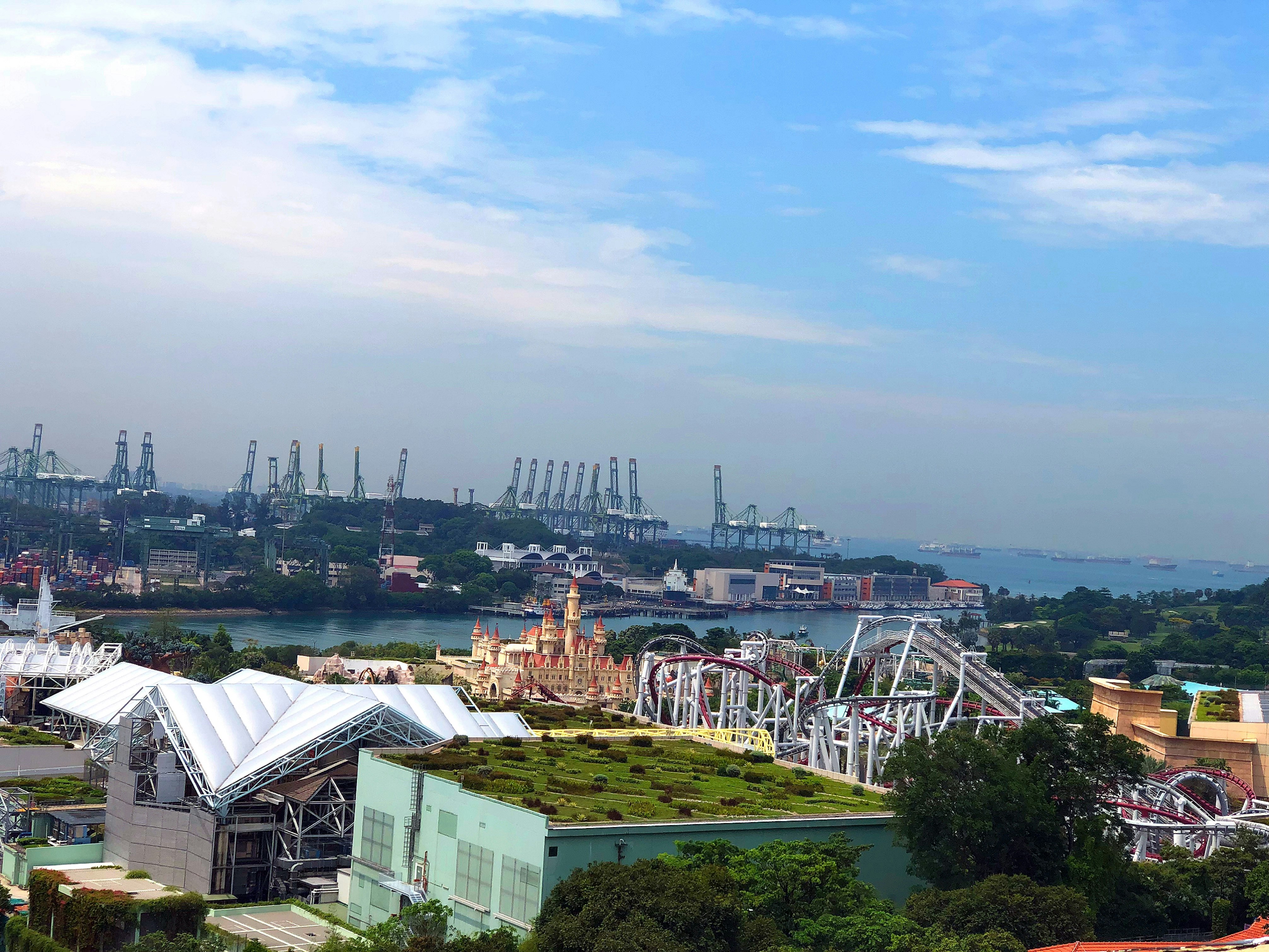 Blick auf einen Küstenhafen mit Industrieanlagen und Riesenrad