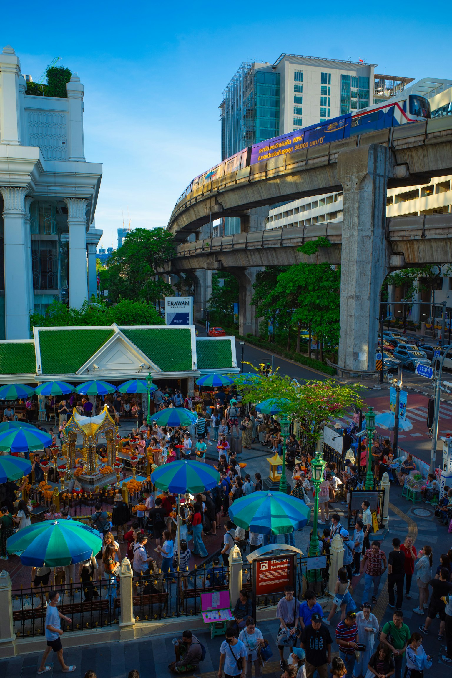 A bustling city scene with people gathered at a market and an elevated train