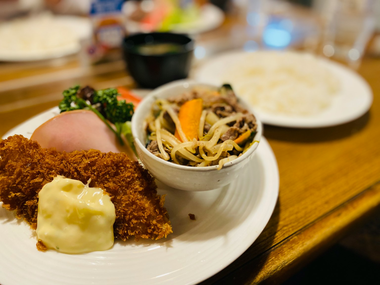 装有炸食和沙拉的盘子旁边是一碗米饭