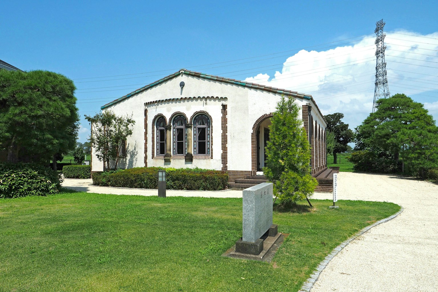 A white building surrounded by greenery and blue sky