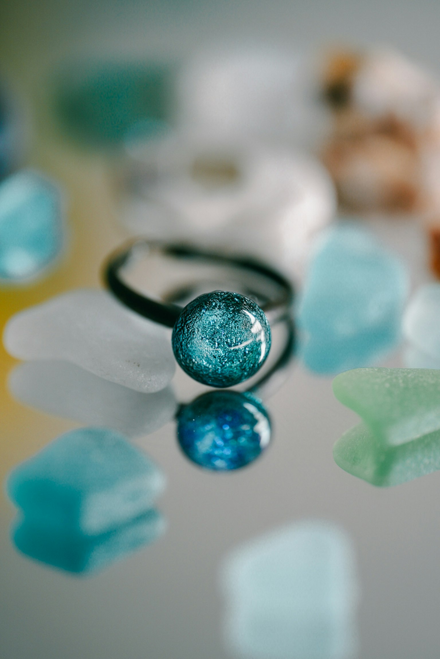 Ein blauer Glasring auf bunten Edelsteinen platziert