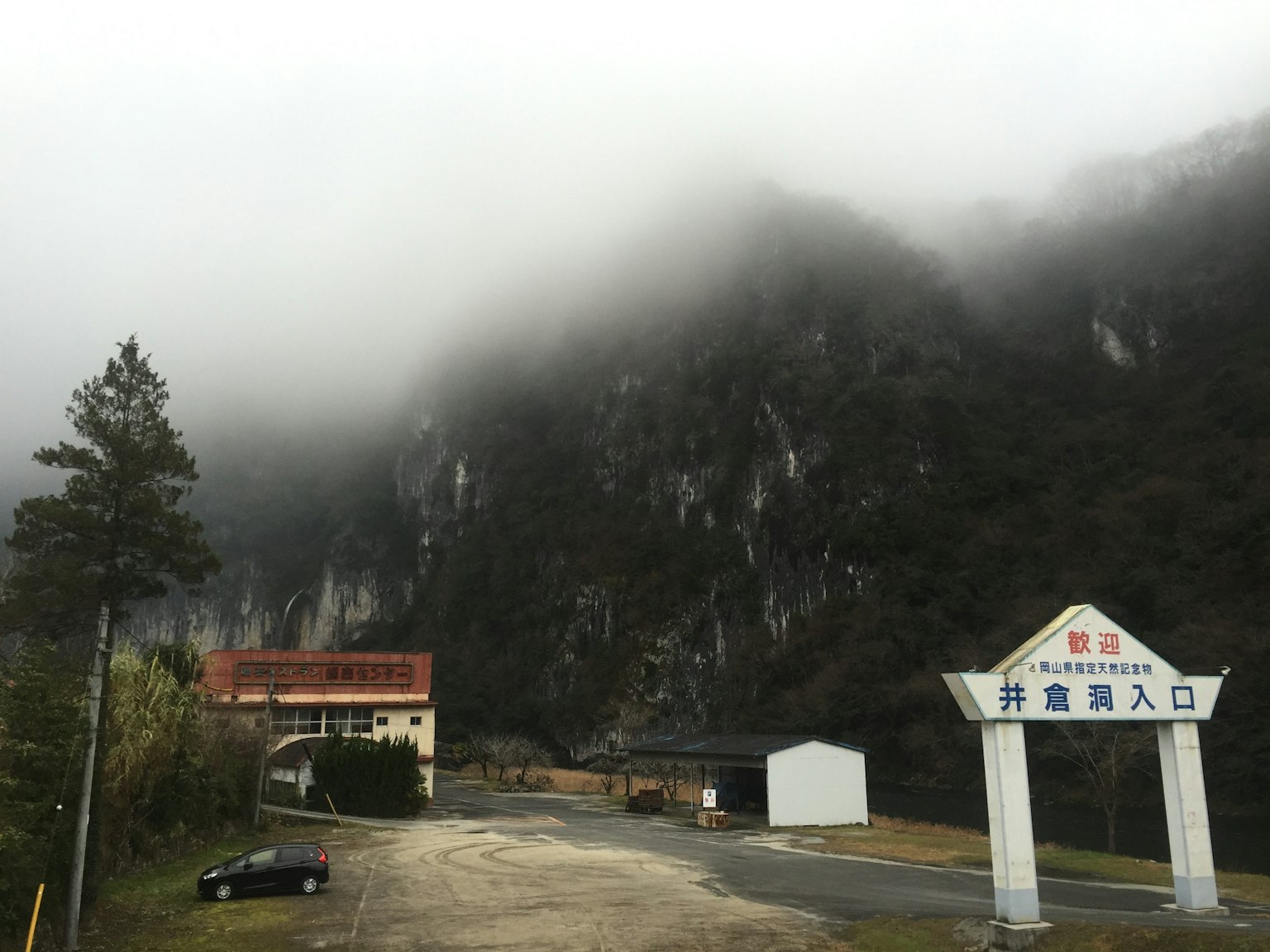 Gunung berkabut dengan bangunan tua dan papan