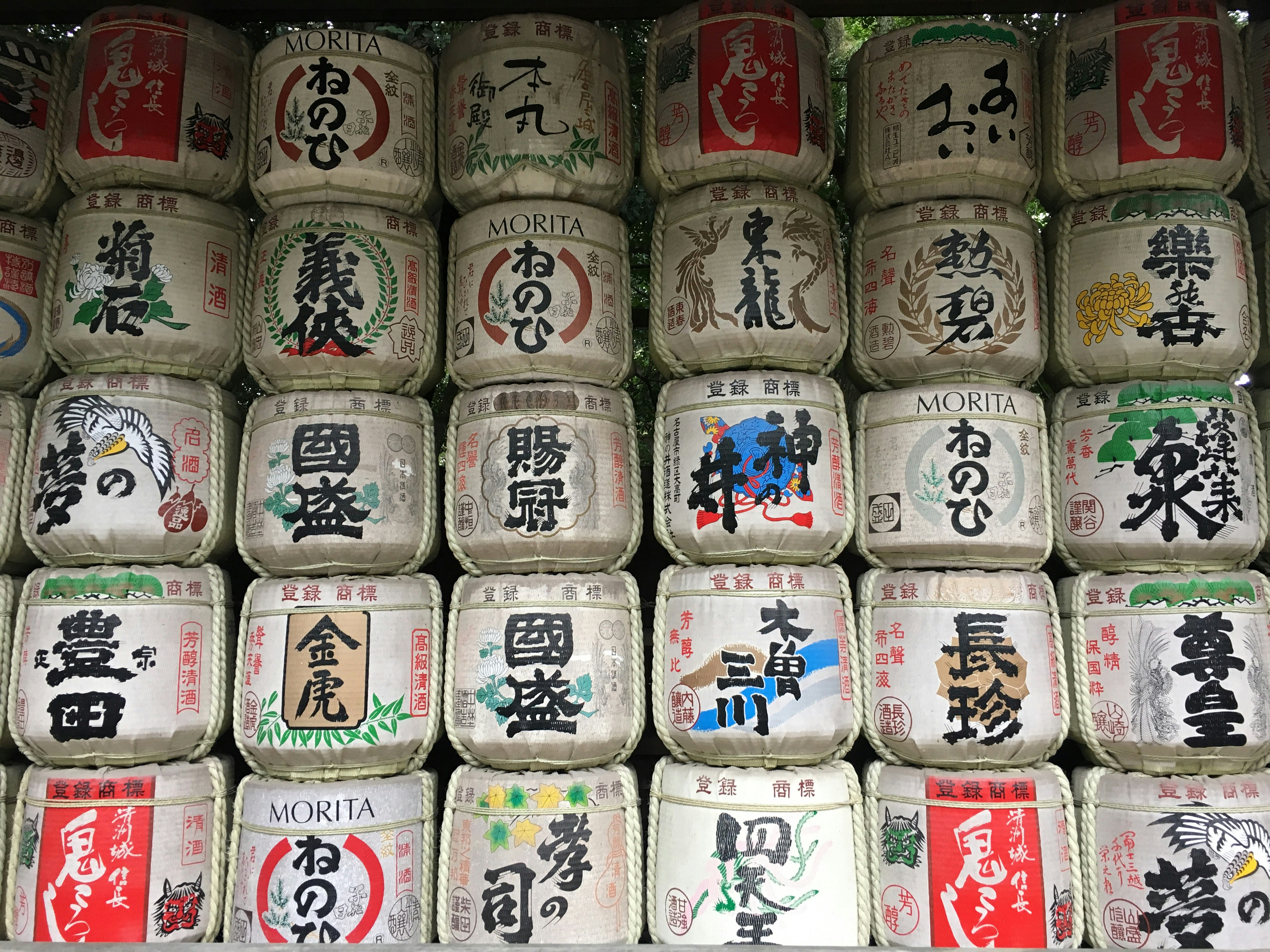 和柄の陶器の樽に並ぶ日本酒ラベルの文字