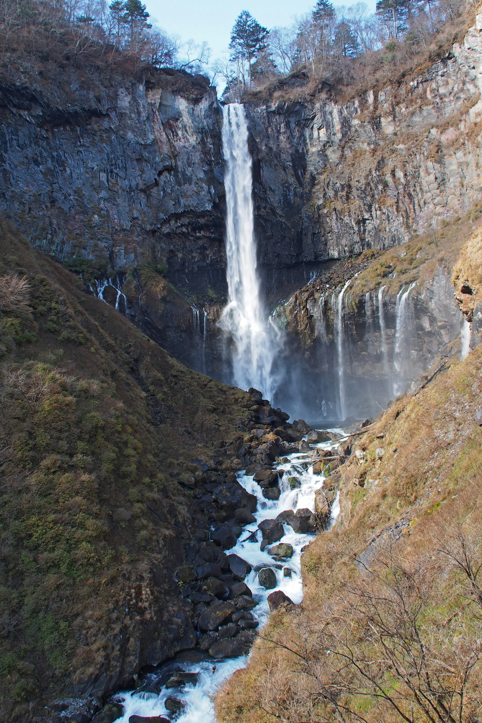 美丽的风景，瀑布从岩石悬崖上倾泻而下，四周环绕着绿色植被