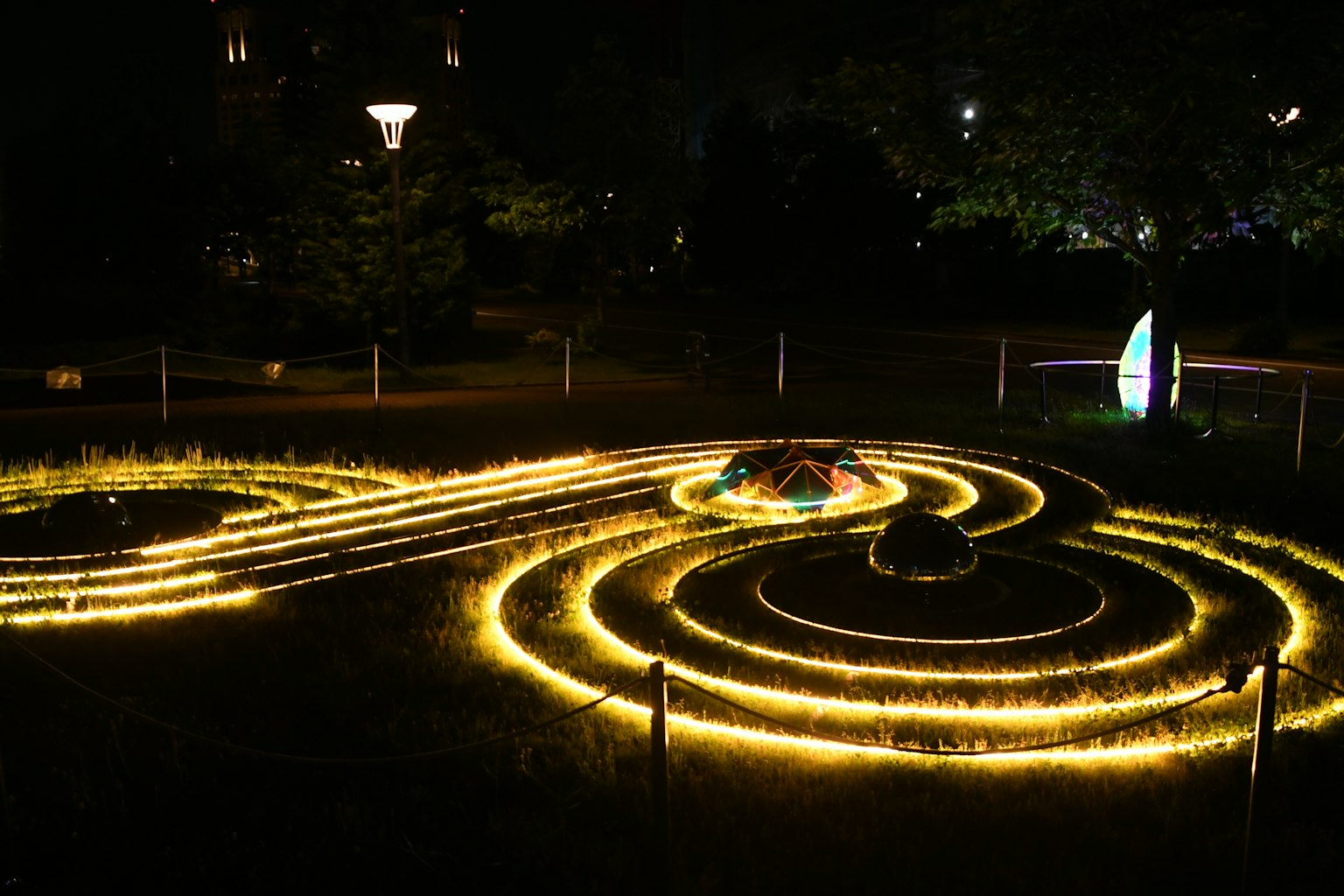 Jalur cahaya spiral yang bersinar di taman gelap di malam hari