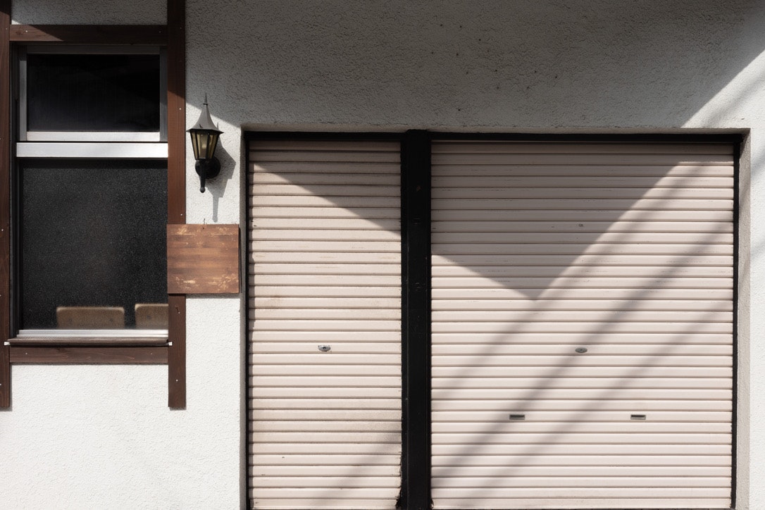 facciata di una casa con garage a saracinesca chiusa e ingresso