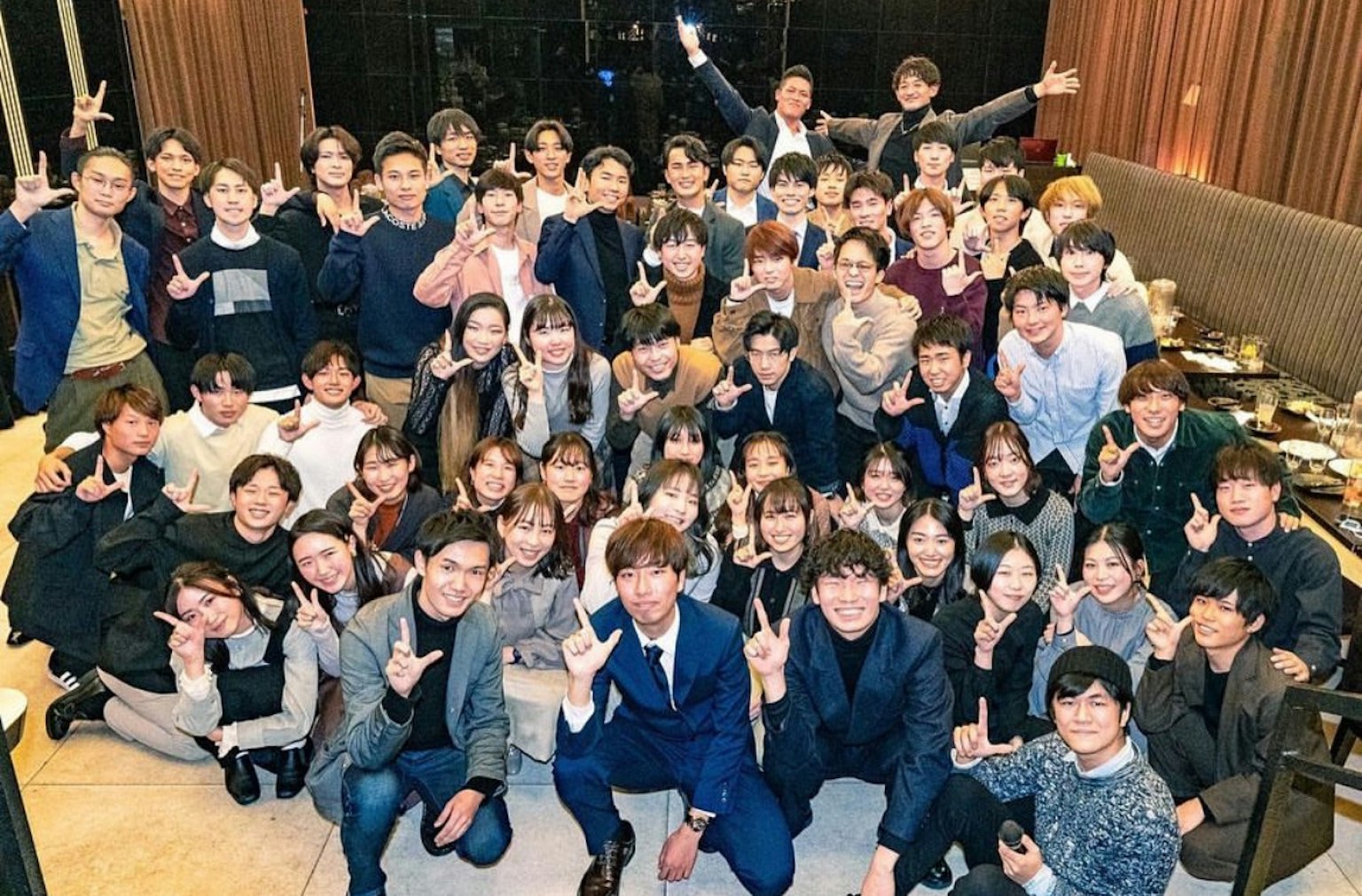 ภาพกลุ่มของคนจำนวนมากที่ยิ้มและโพสต์ในบรรยากาศที่ไม่เป็นทางการถึงทางการ