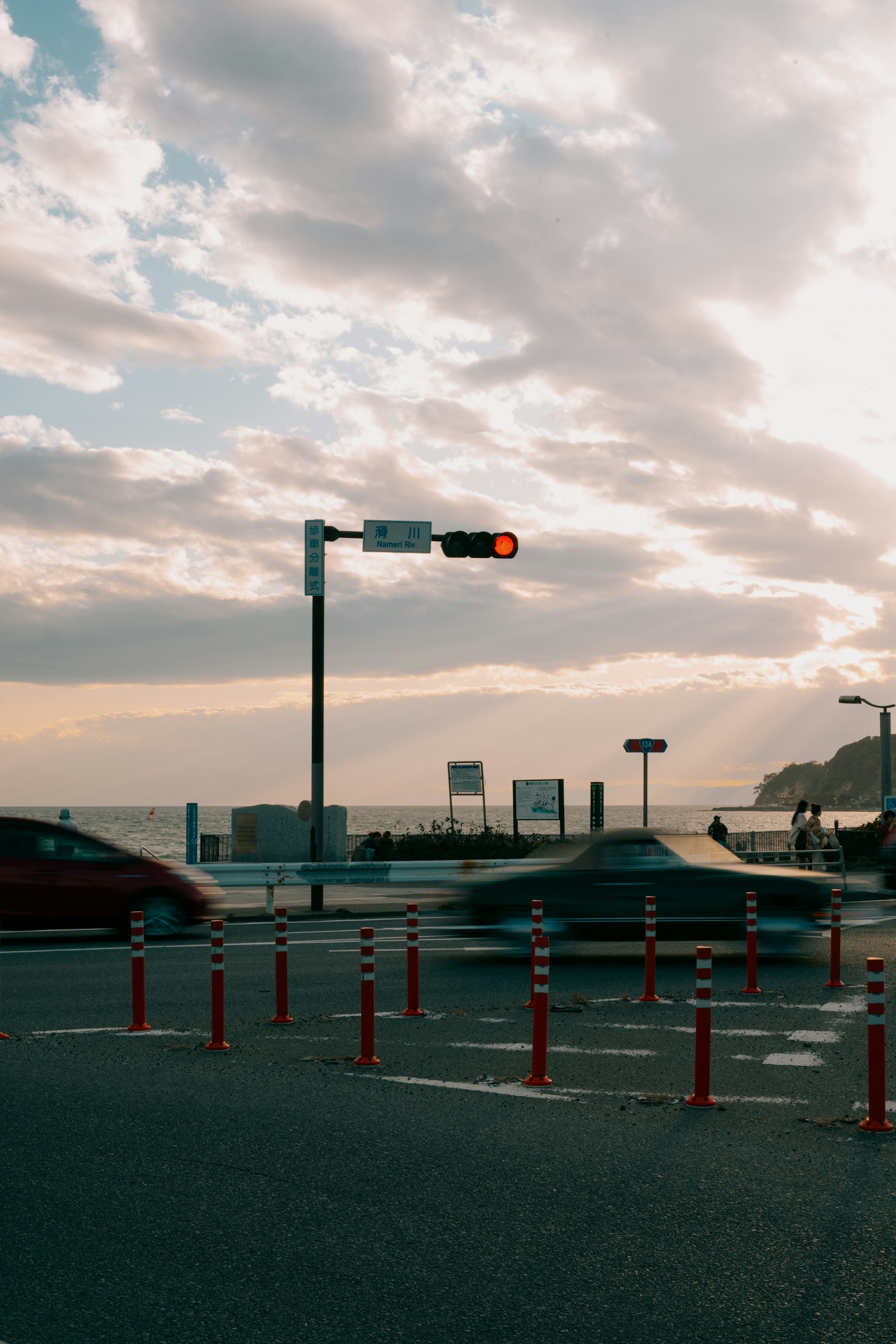 Ampel an einer Kreuzung nahe dem Meer mit fahrenden Autos