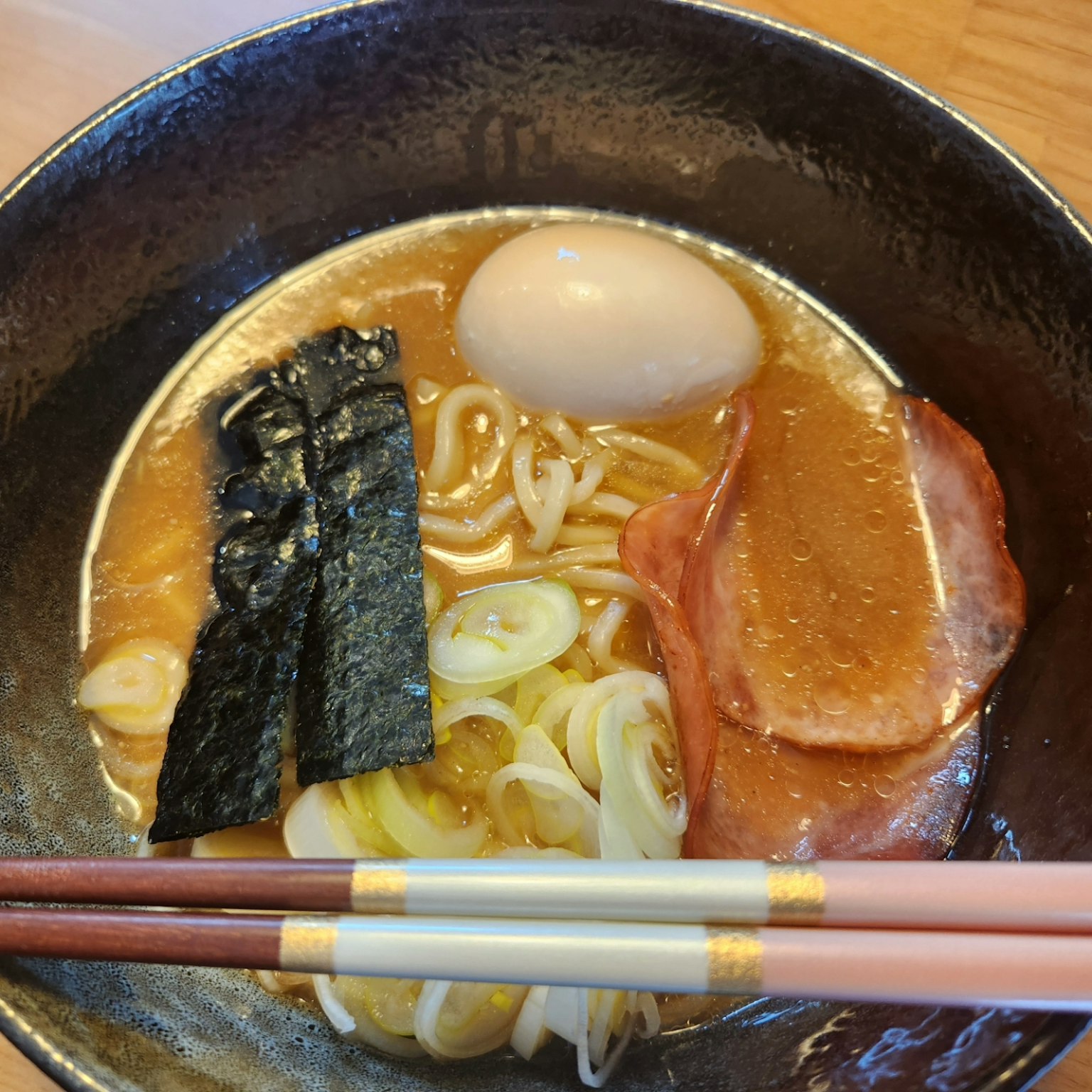 Un bol de ramen avec bouillon, nouilles, œuf et garnitures