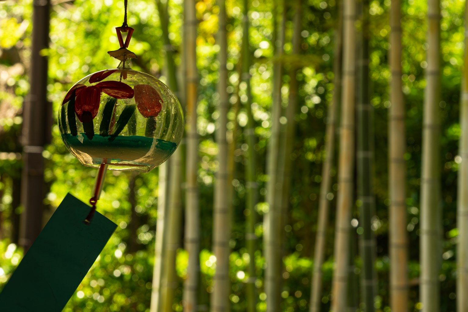 Close-up lonceng angin yang indah tergantung di hutan bambu
