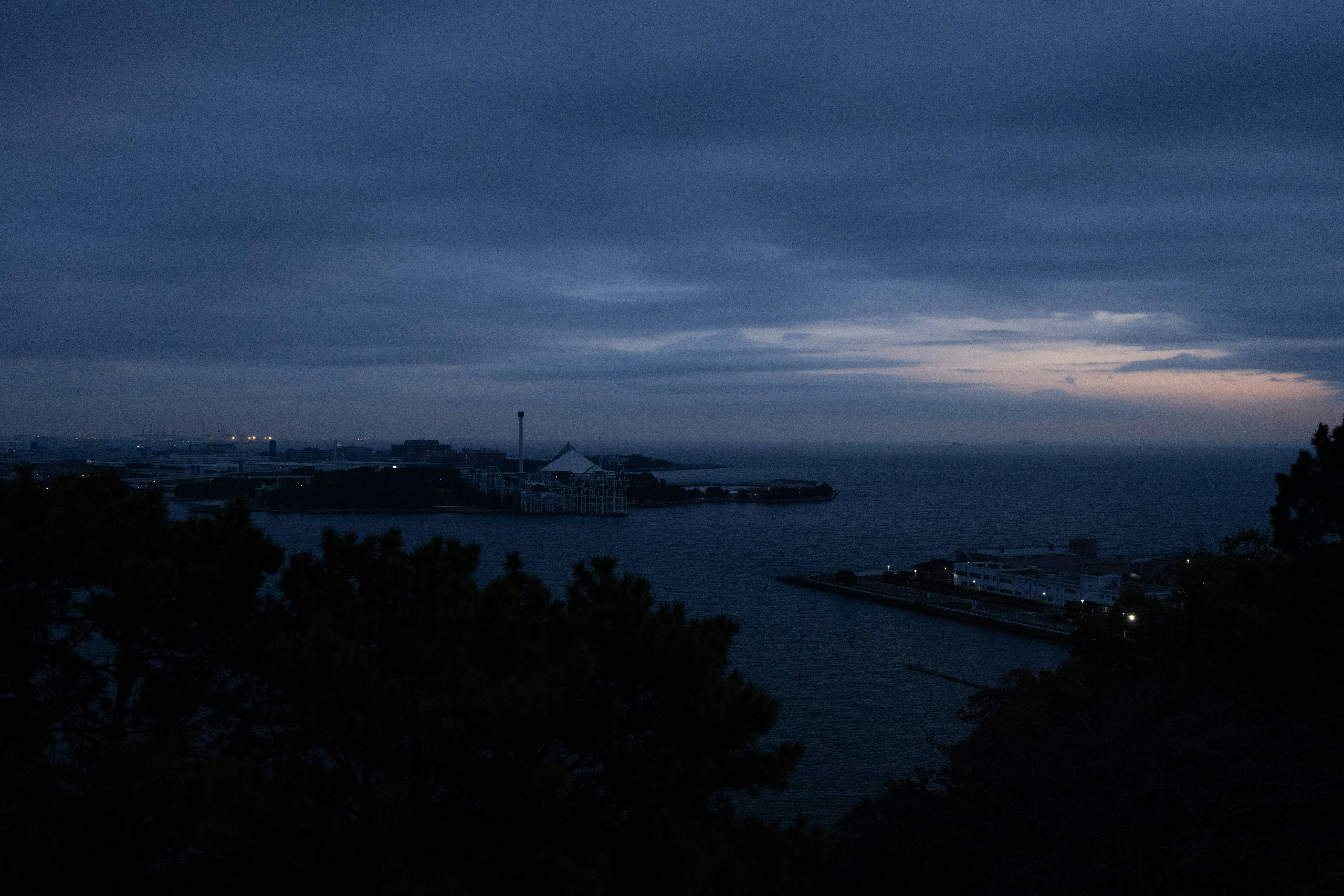 夕暮れの海と港の夜景が見える湾岸の眺め