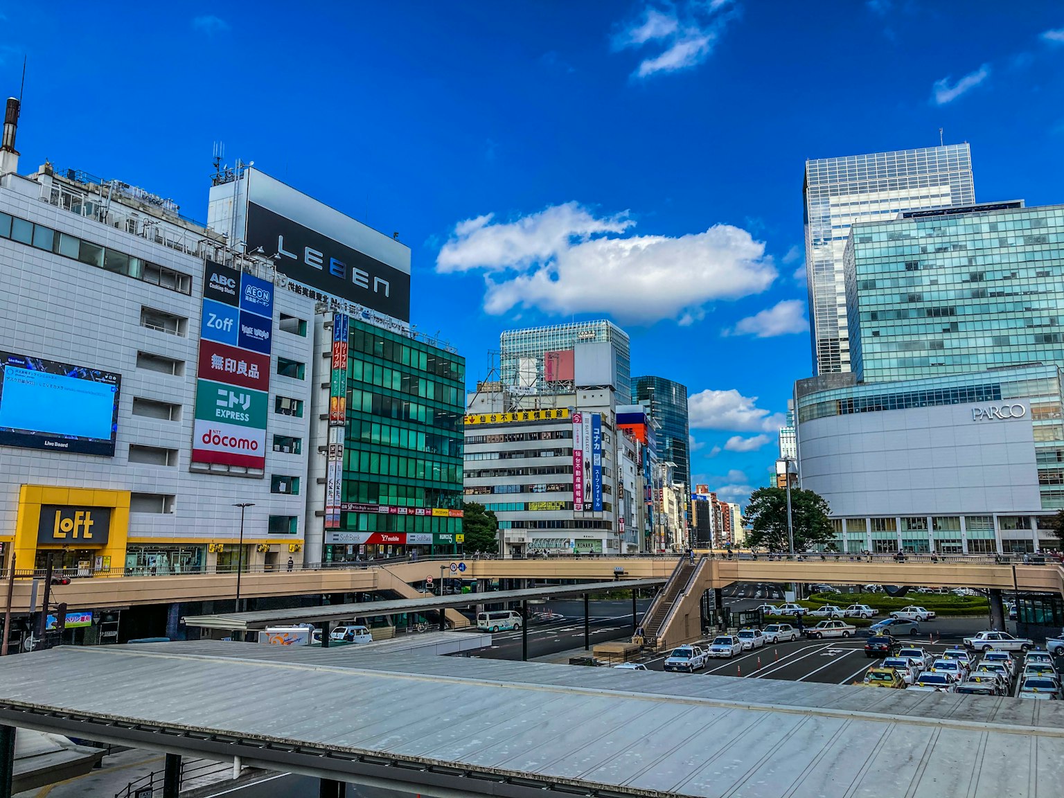 Paysage urbain avec des immeubles de grande hauteur et des espaces commerciaux sous un ciel bleu