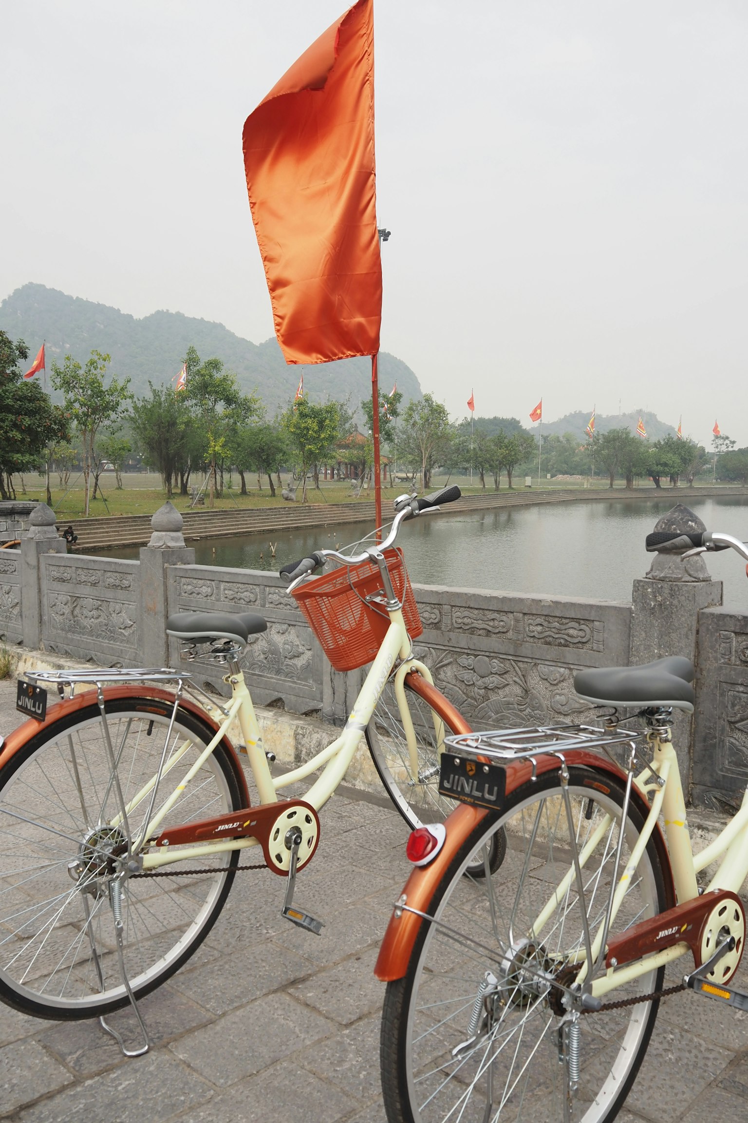 河邊停放的帶橙色旗幟的自行車