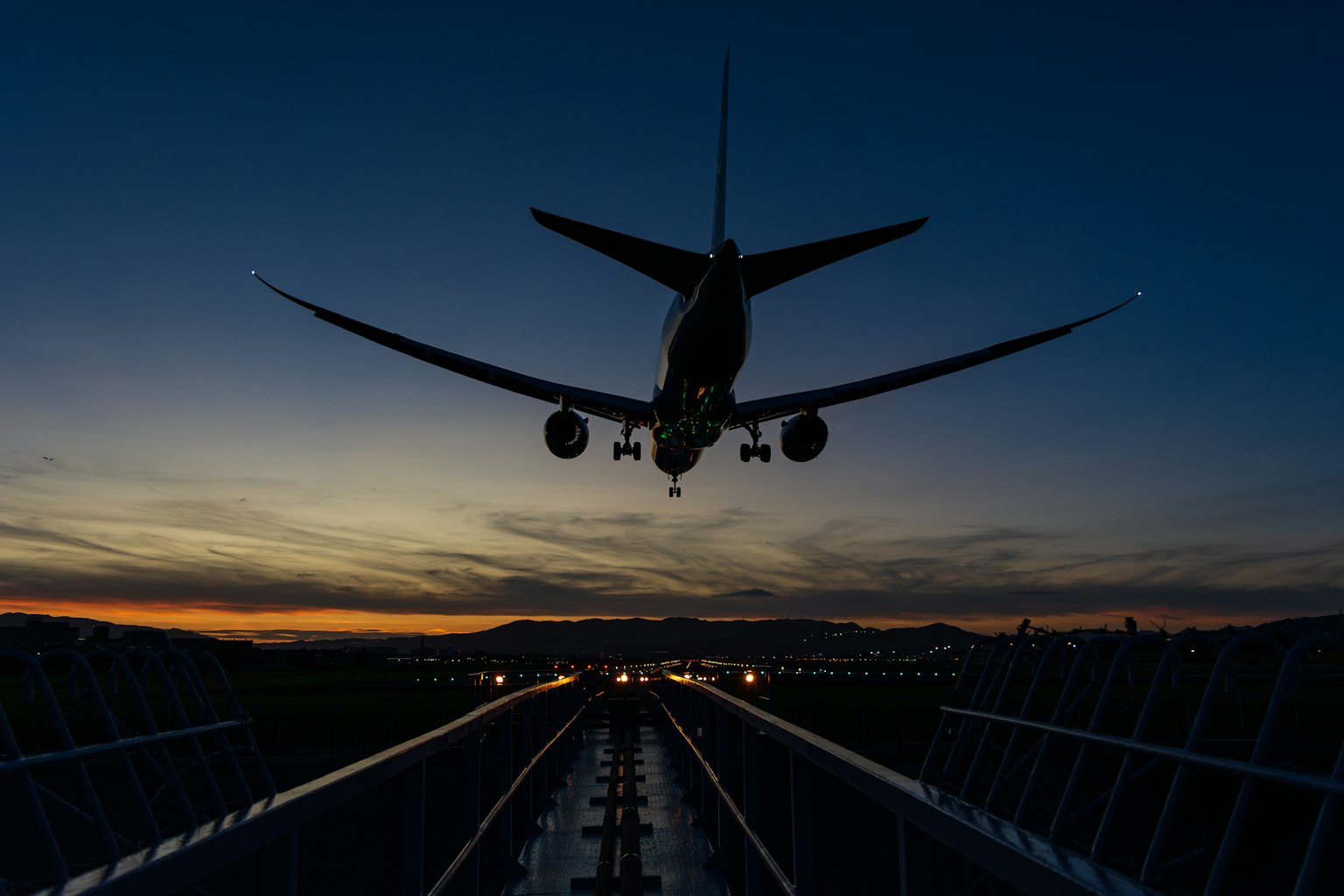 夕暮れ時に飛行機が着陸する様子が写っている