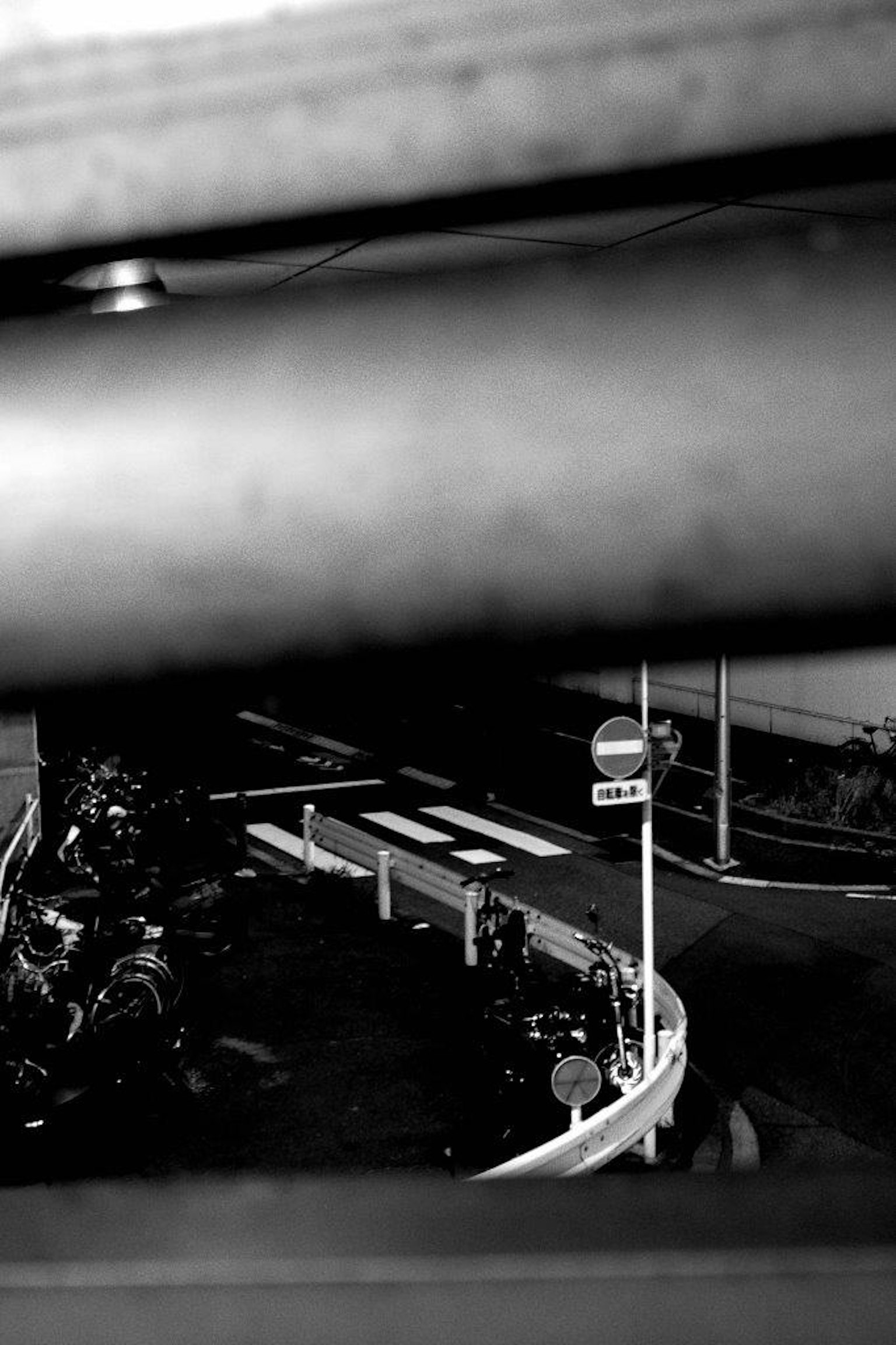 Schwarz-weiße Stadtszene mit einer kurvigen Straße und einer Verkehrsampel