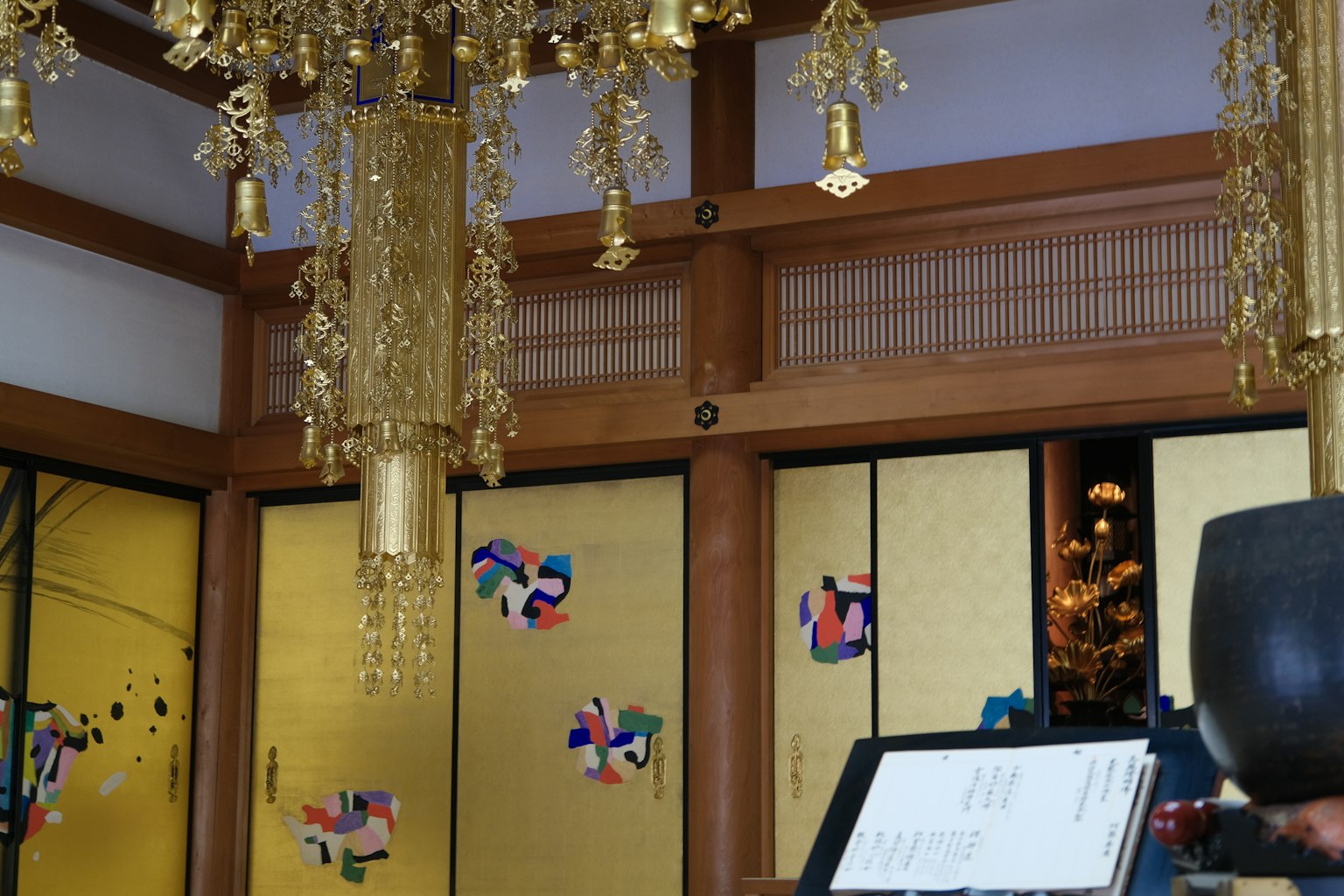 Interior ruangan tradisional Jepang dengan gantungan lampu emas dinding kayu dan pintu emas dekoratif