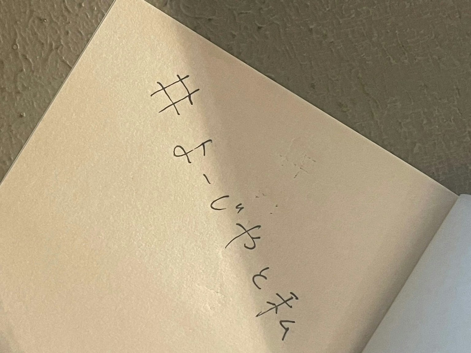 Note manuscrite sur une page avec un hashtag