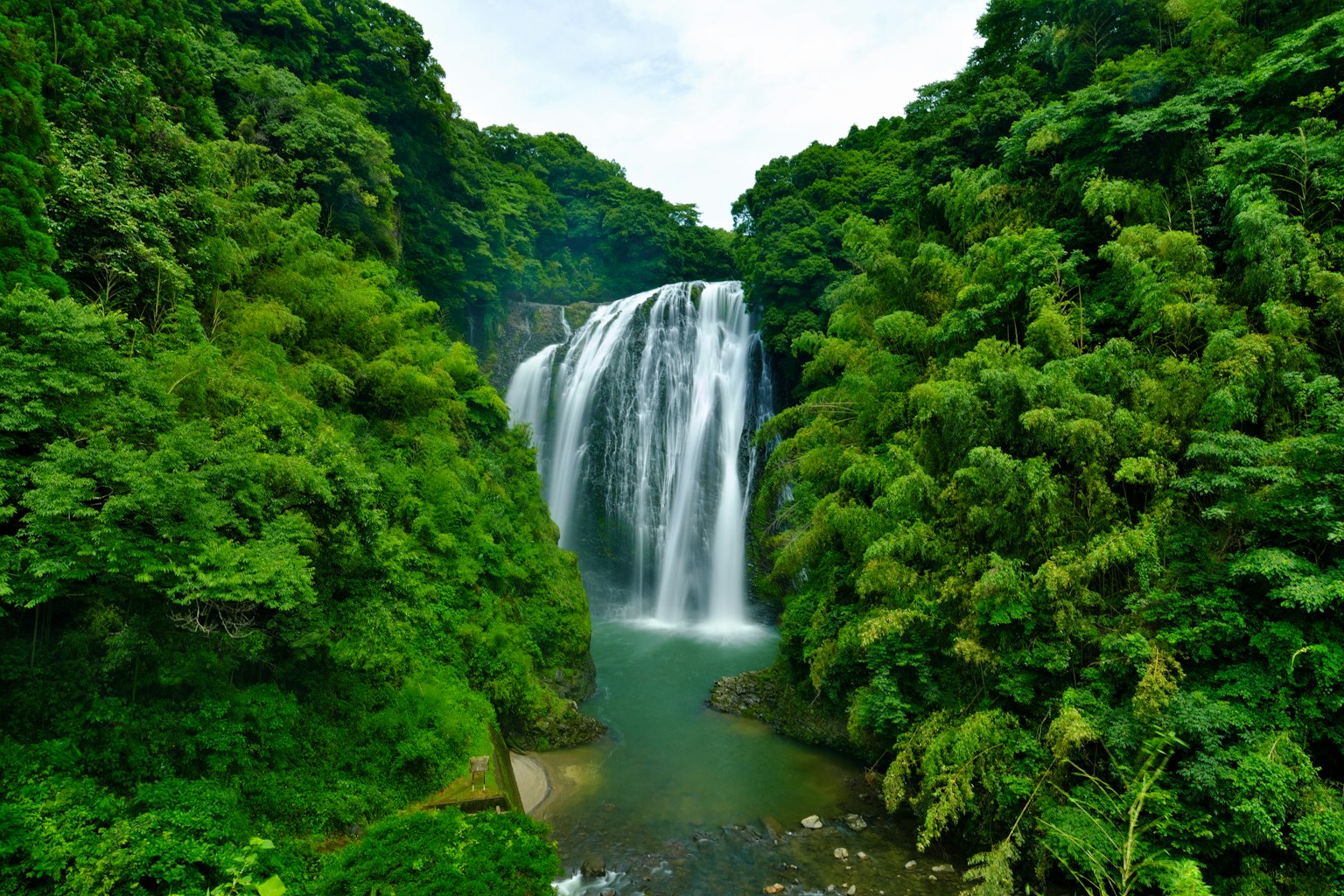Air terjun yang indah dikelilingi hutan hijau subur