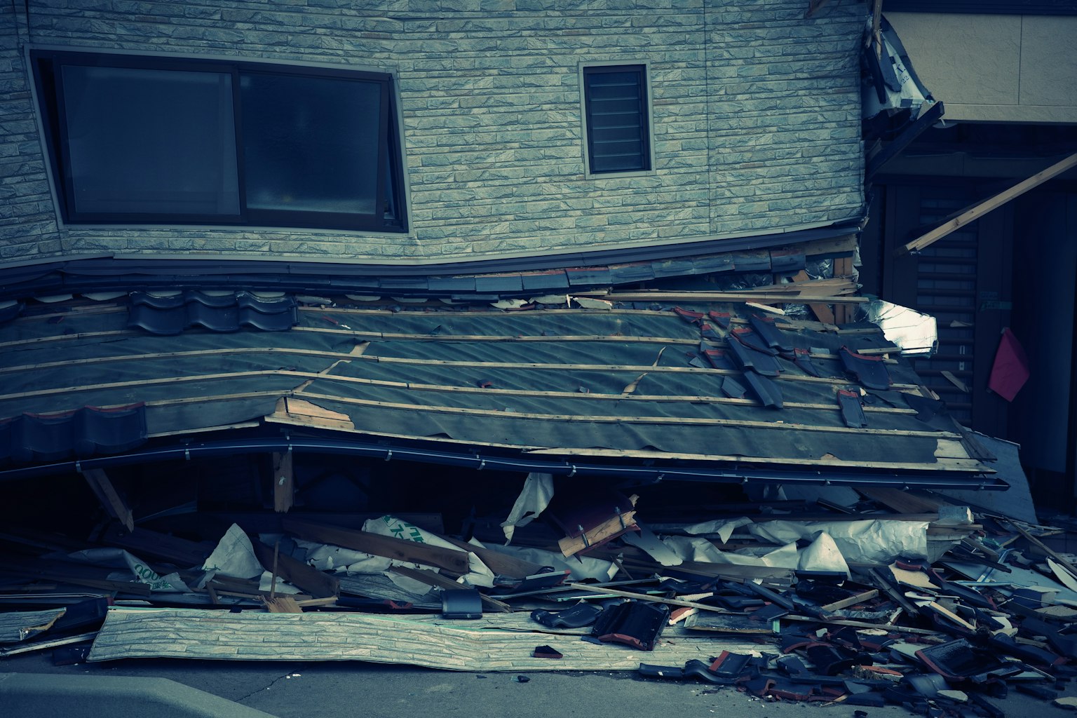 Parte di un edificio danneggiato da un terremoto Detriti e travi di legno sparsi