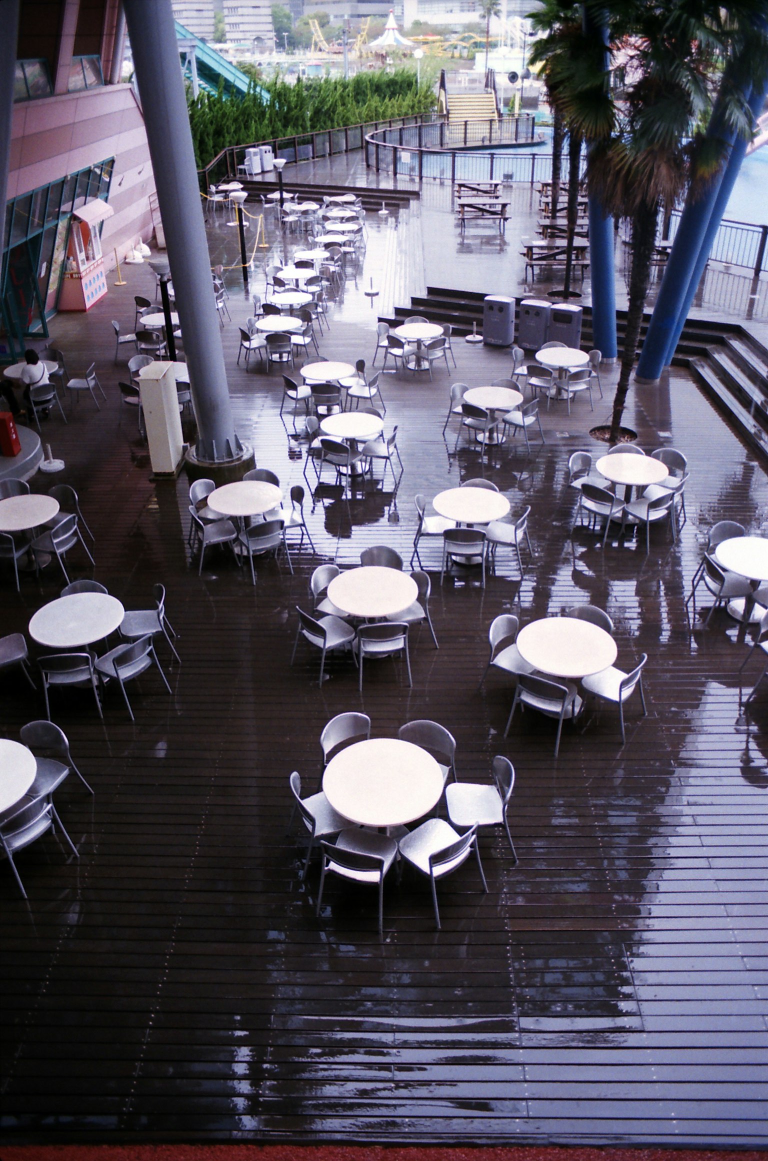 Terrasse mouillée par la pluie avec des tables et des chaises disposées