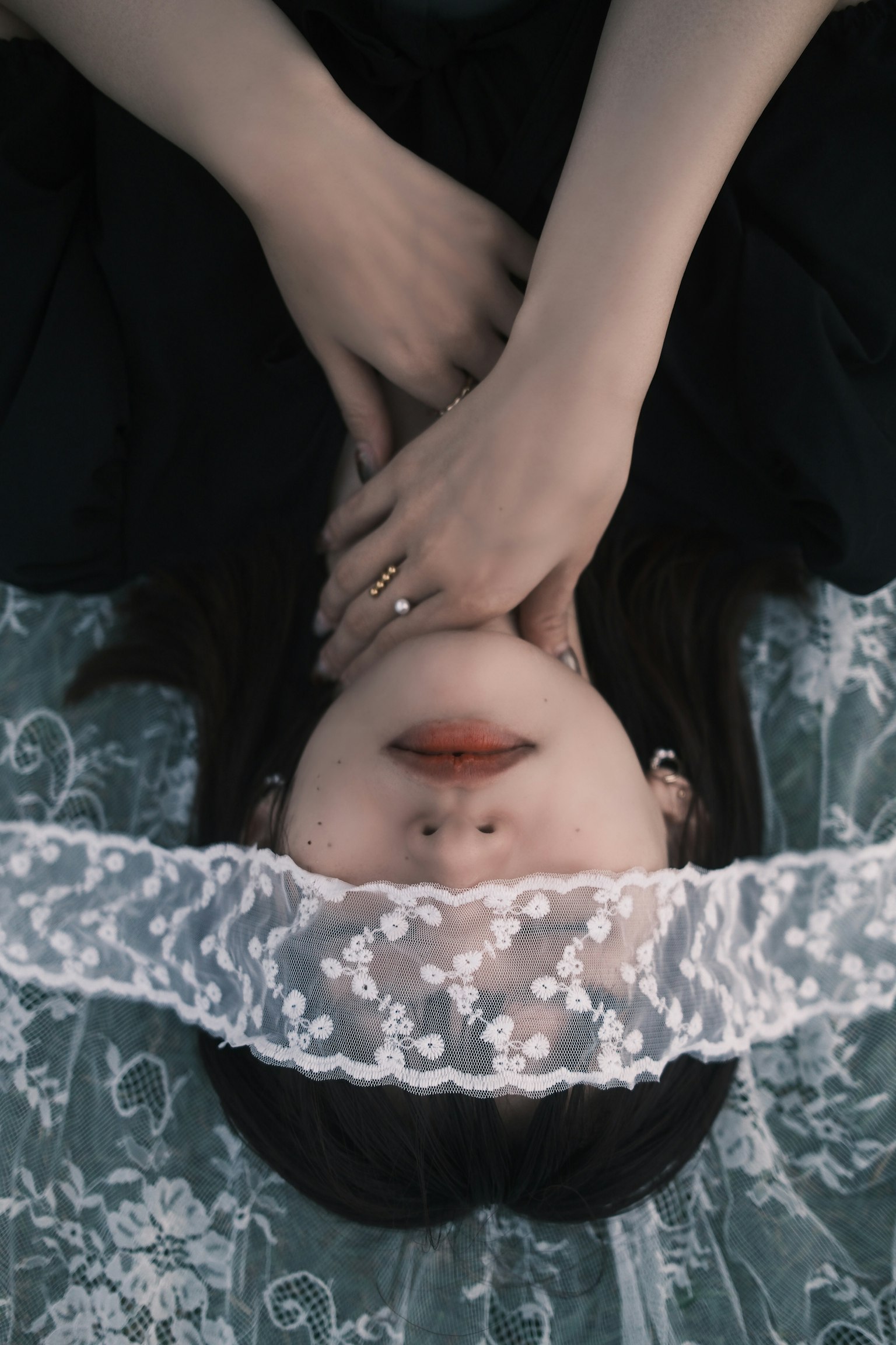 女性がレースのベールをかぶり、黒い服を着ている上向きのポーズ