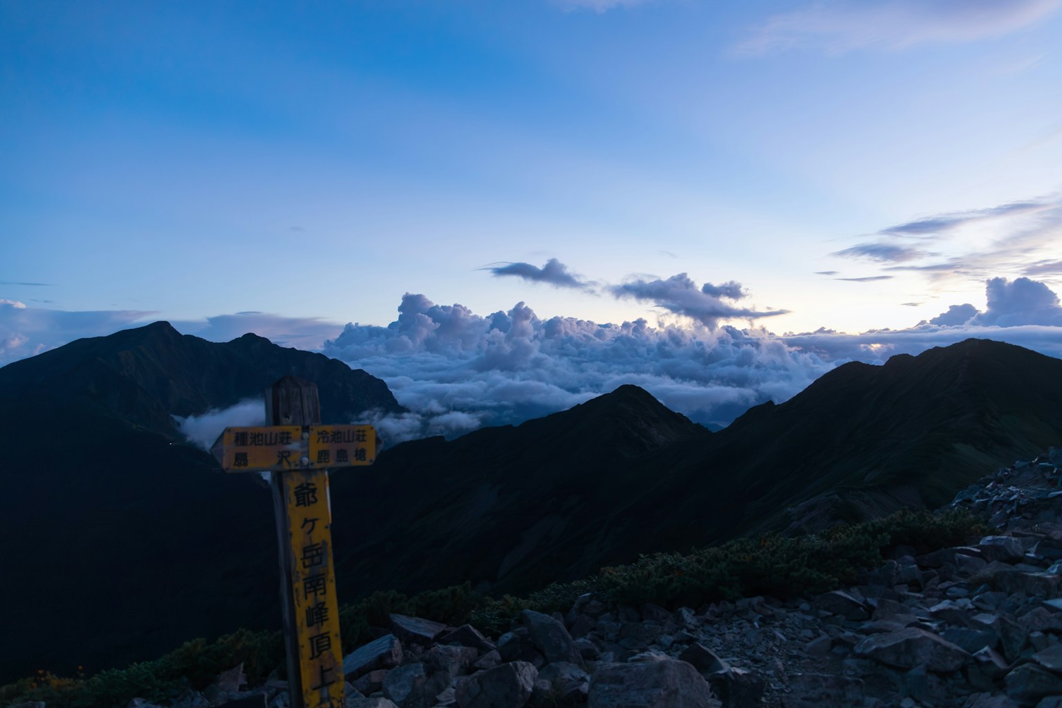 Pemandangan matahari terbenam yang indah dari puncak gunung dengan awan di latar belakang