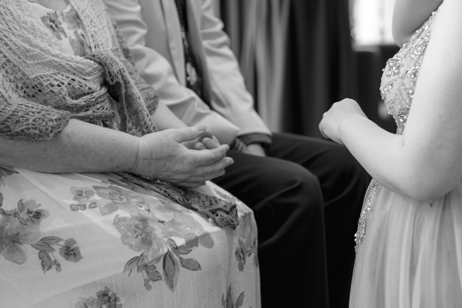 Photo en noir et blanc montrant les mains d'une femme et une robe fleurie