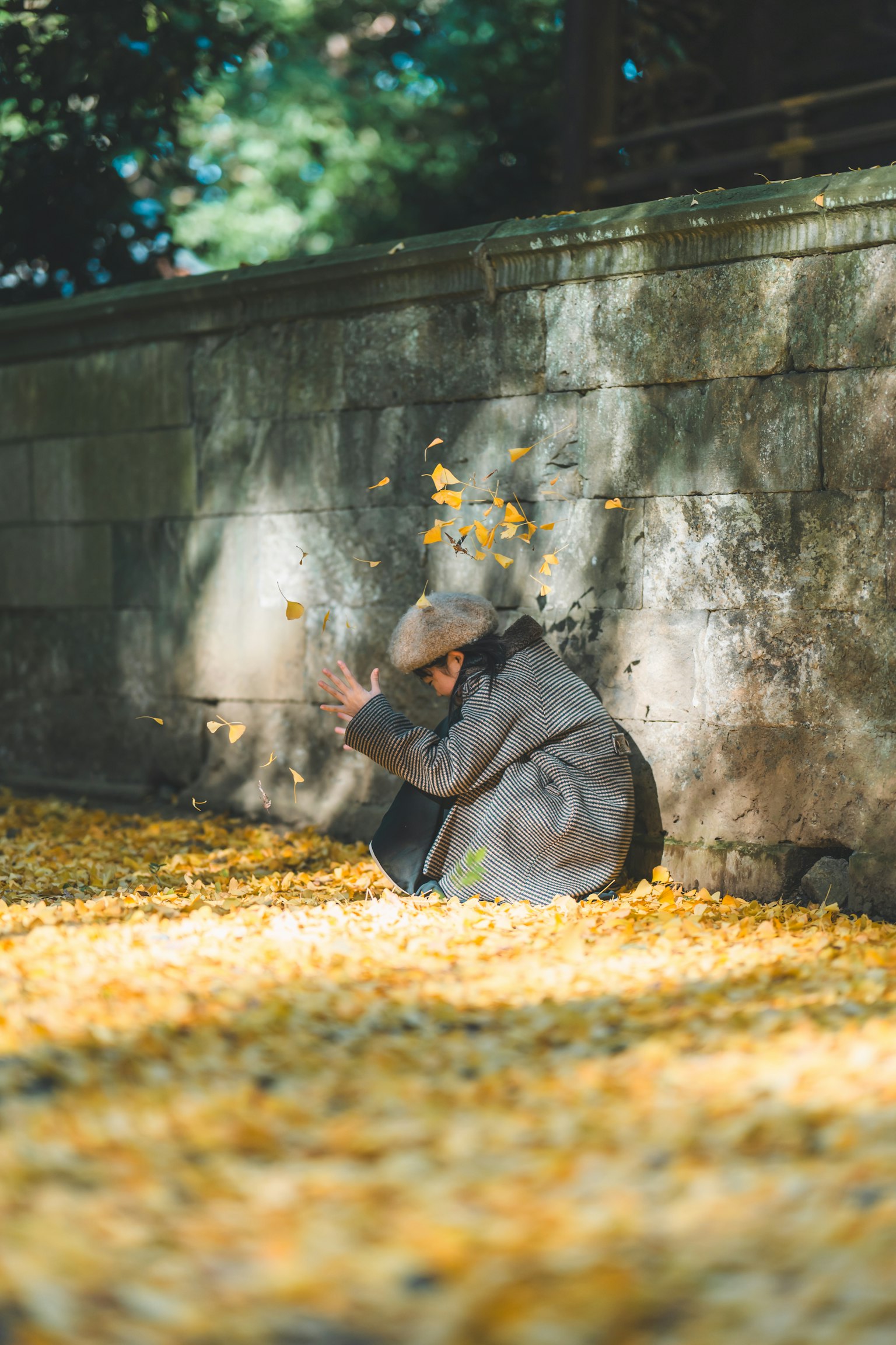 Une personne assise parmi des feuilles mortes dans un cadre extérieur serein