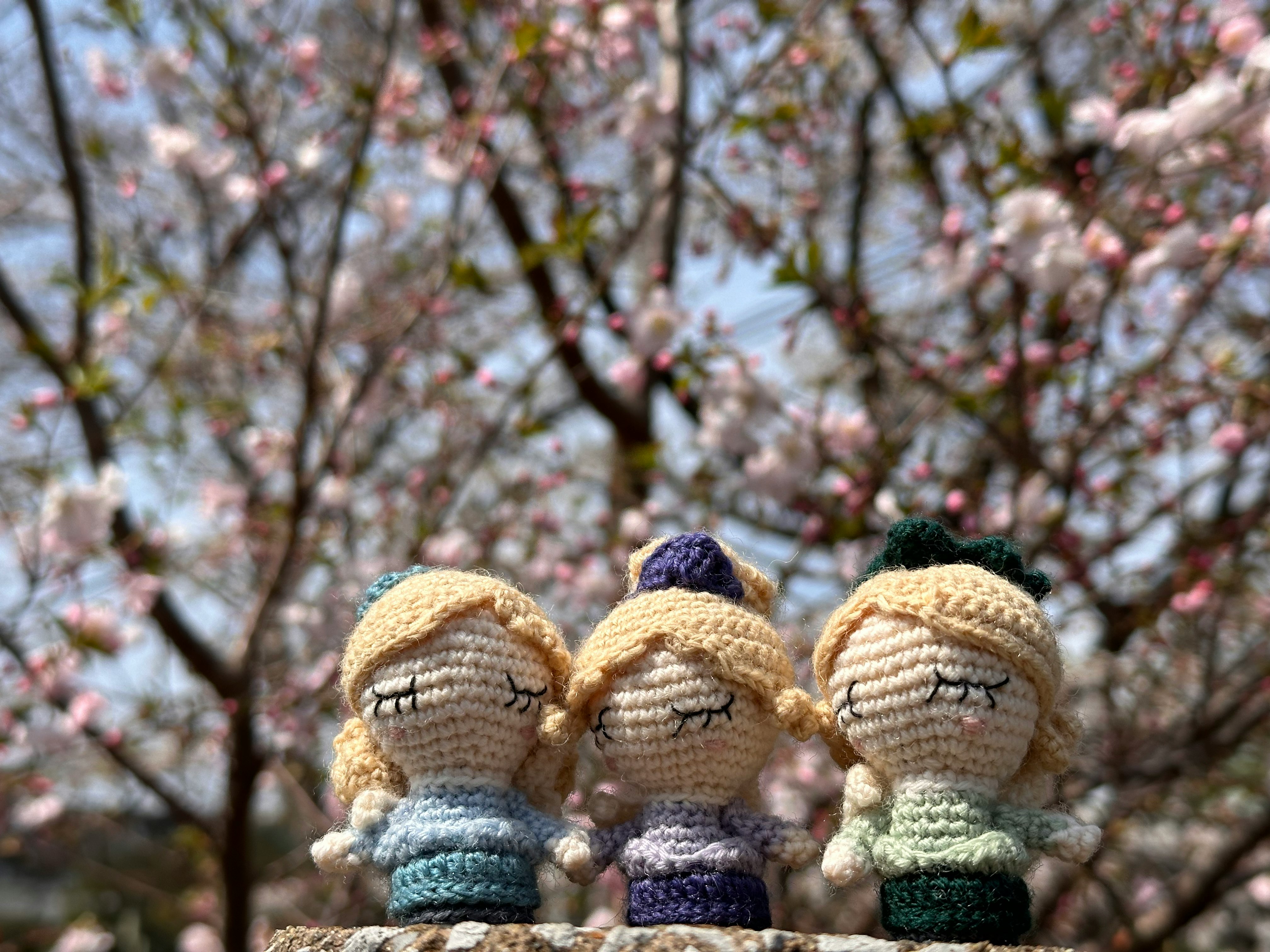 桜の木の前で並ぶあみぐるみのぬいぐるみ